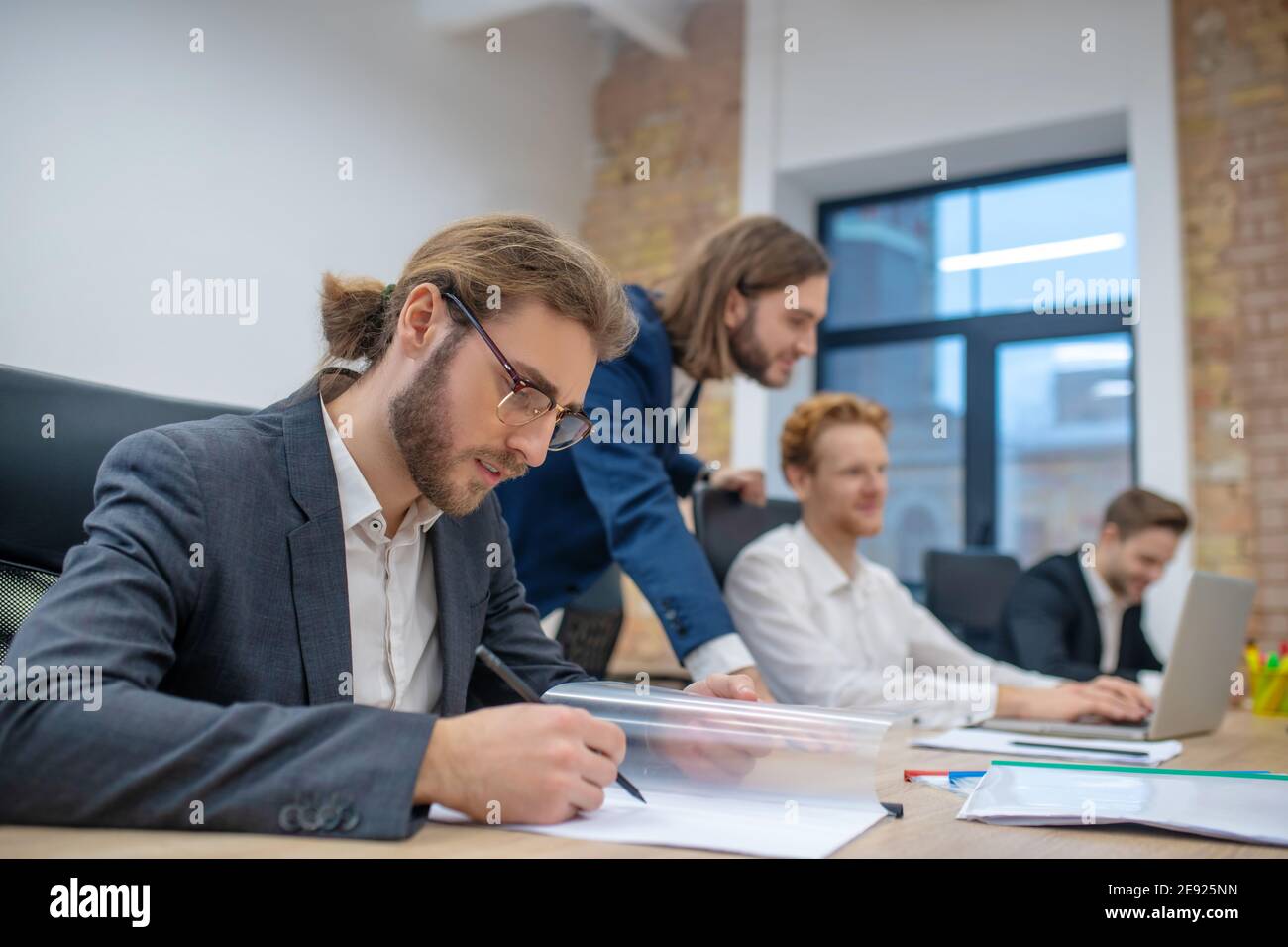 Man in glasses with pencil looking at document Stock Photo