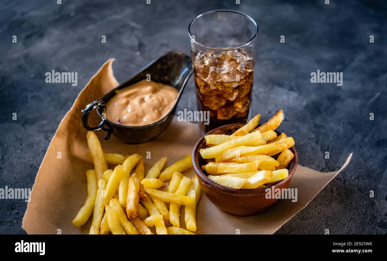 French fries with sauce and drink laid on pergament paper Stock Photo