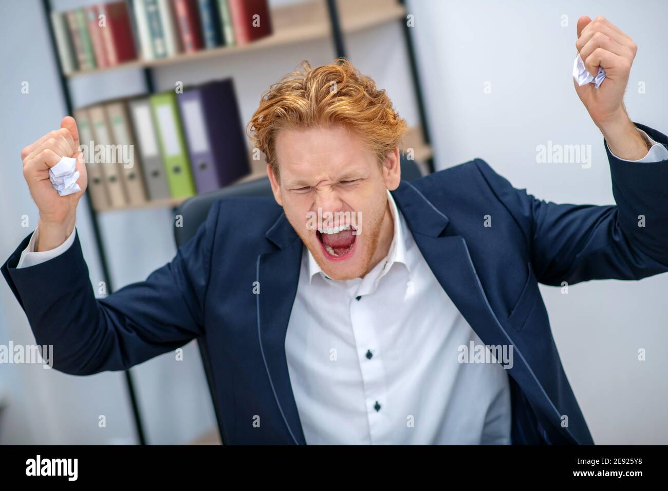Angry man with closed eyes and raised fists Stock Photo