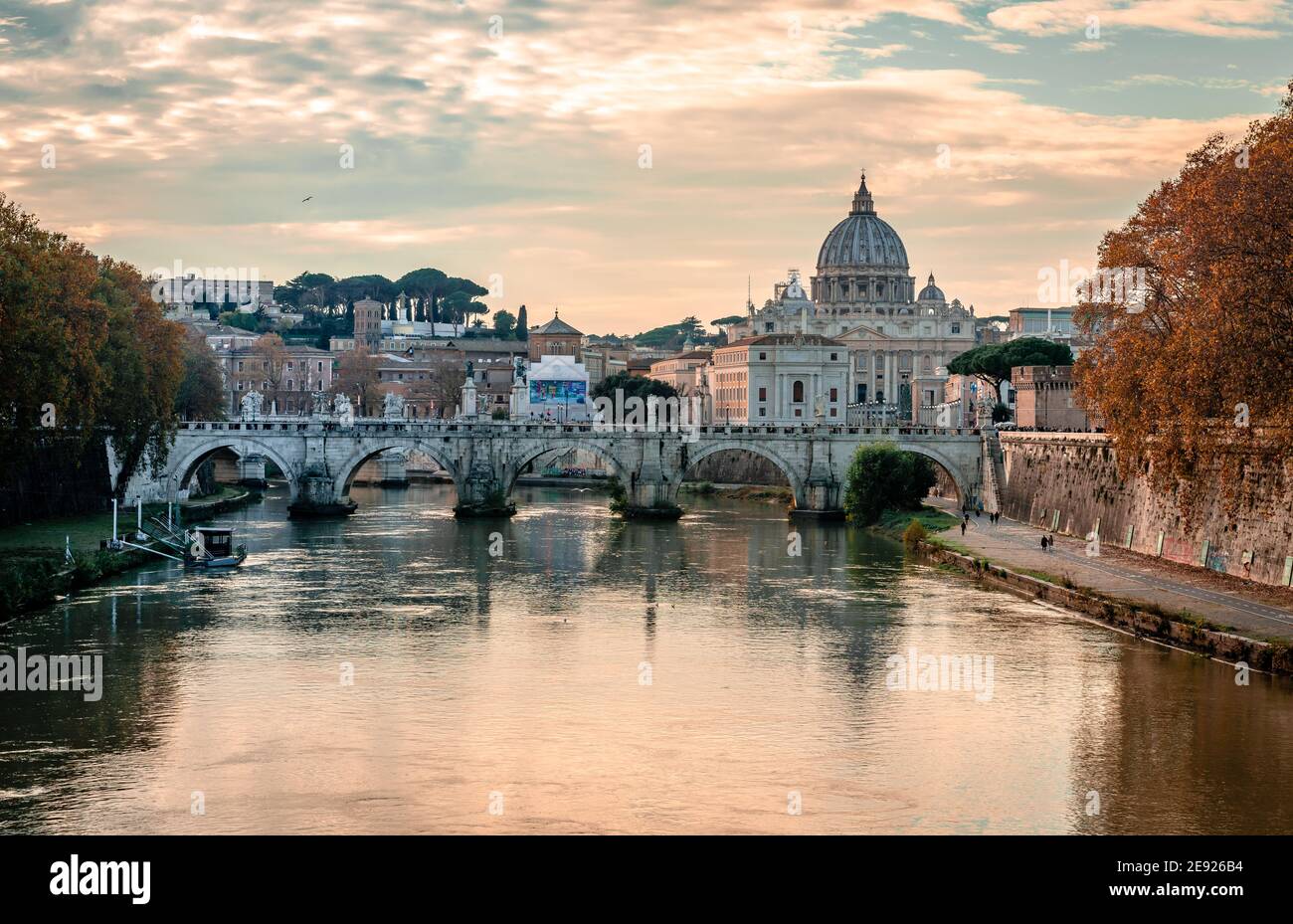 View of Ponte Sant'Angelo (St. Angelo Bridge) that spans river Tiber with the dome of Saint Peter's Basilica in the ba Stock Photo
