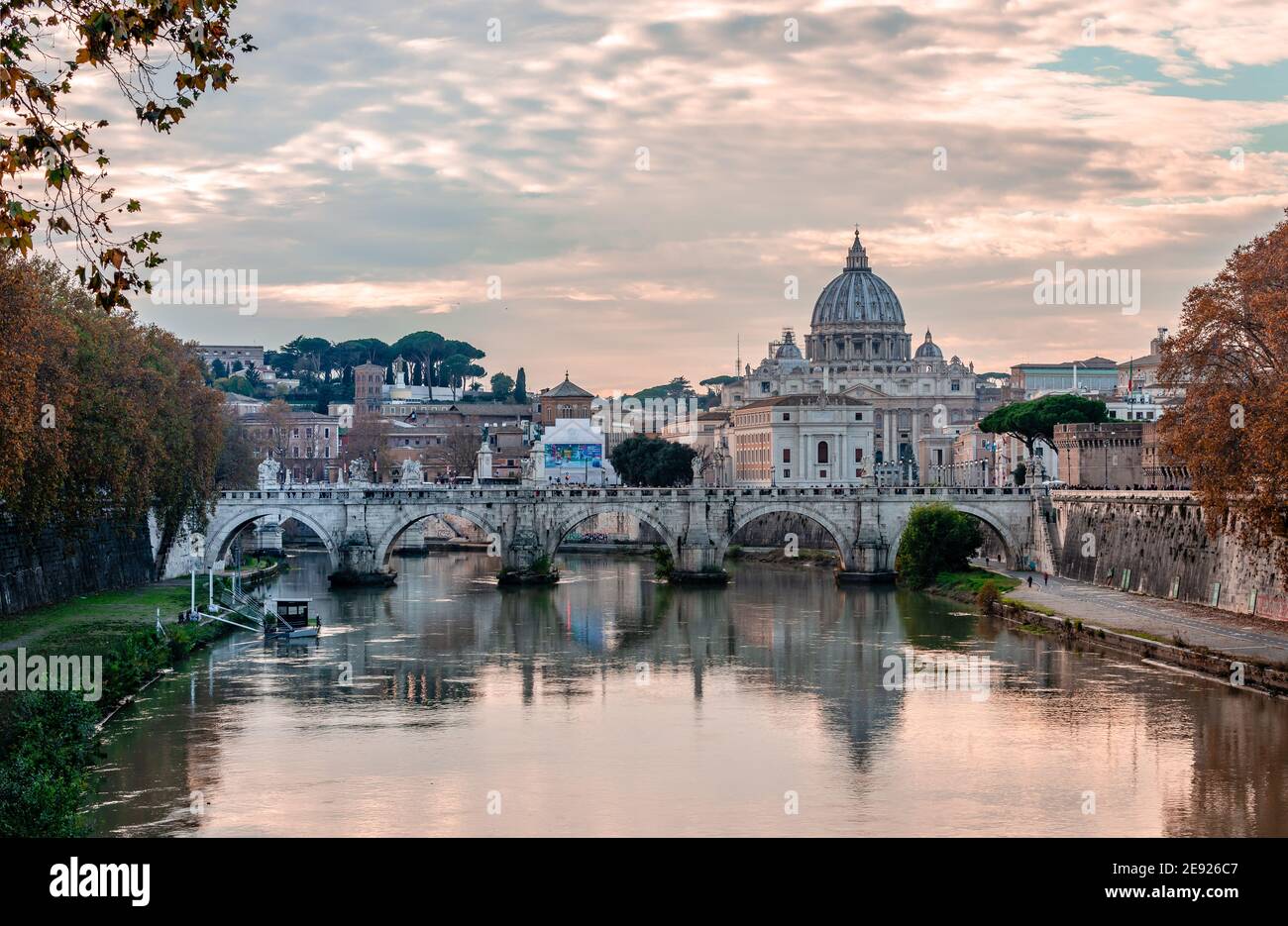 View of Ponte Sant'Angelo (St. Angelo Bridge) that spans river Tiber with the dome of Saint Peter's Basilica in the ba Stock Photo