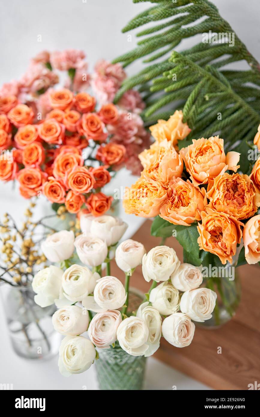 Set of white, green and orange flowers for Interior decorations. The work of the florist at a flower shop. Fresh cut flower. Stock Photo