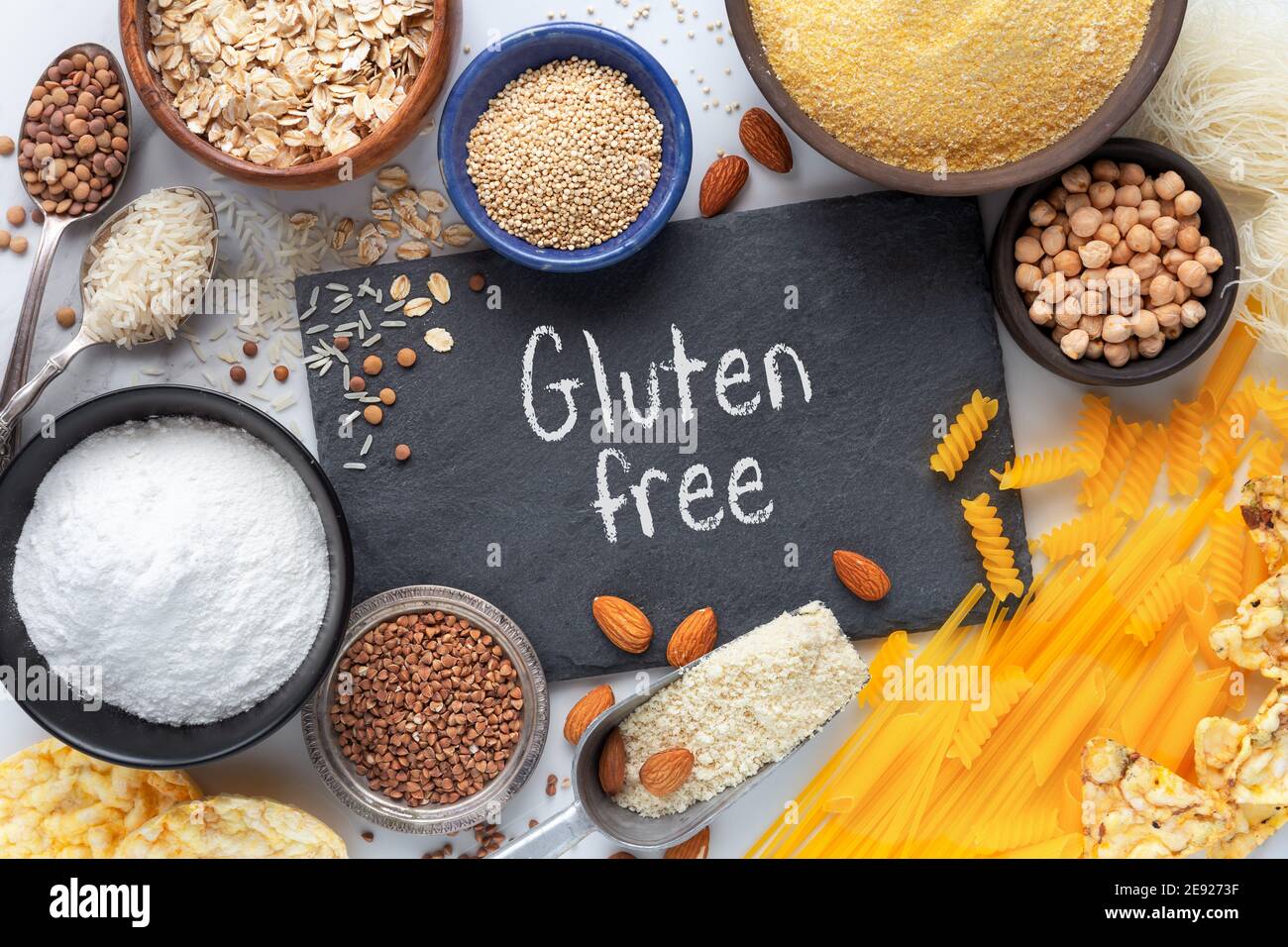 Gluten free food concept showingh the veriety of products - pasta, flour, snacks, legumes and cereal - with Gluten free text written on black slate bo Stock Photo