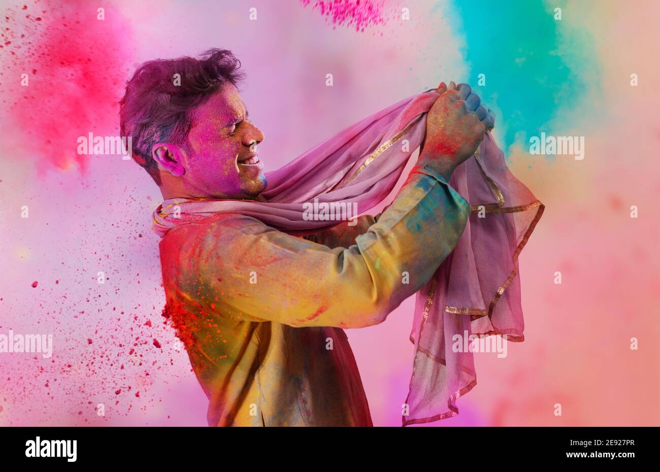 Man with gulal on his face dancing holding a dupatta in his hand on Holi Stock Photo