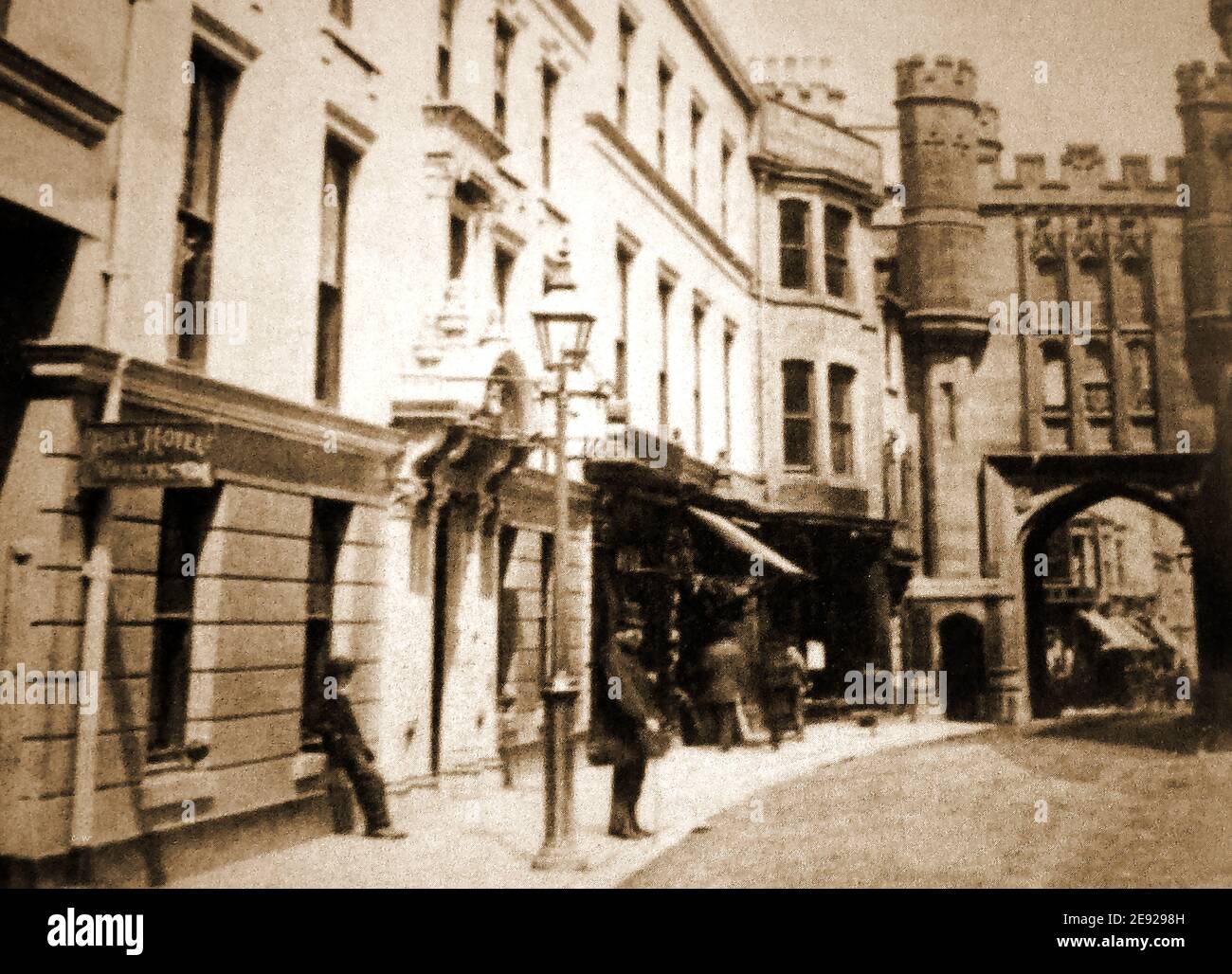 An old photograph taken in Scarborough, North Yorkshire, UK, showing  the former (rebuilt) Newborough Bar which was part of the old town walls.  The Bull Inn is situated to the left . The bar with its archway  containing the town's jail was rebuilt in 1843 with turrets. In the distance, now out of view,  is Scarborough Castle and its walls which were greatly damaged during the bombardment of Scarborough by German Warships in WWI. Stock Photo