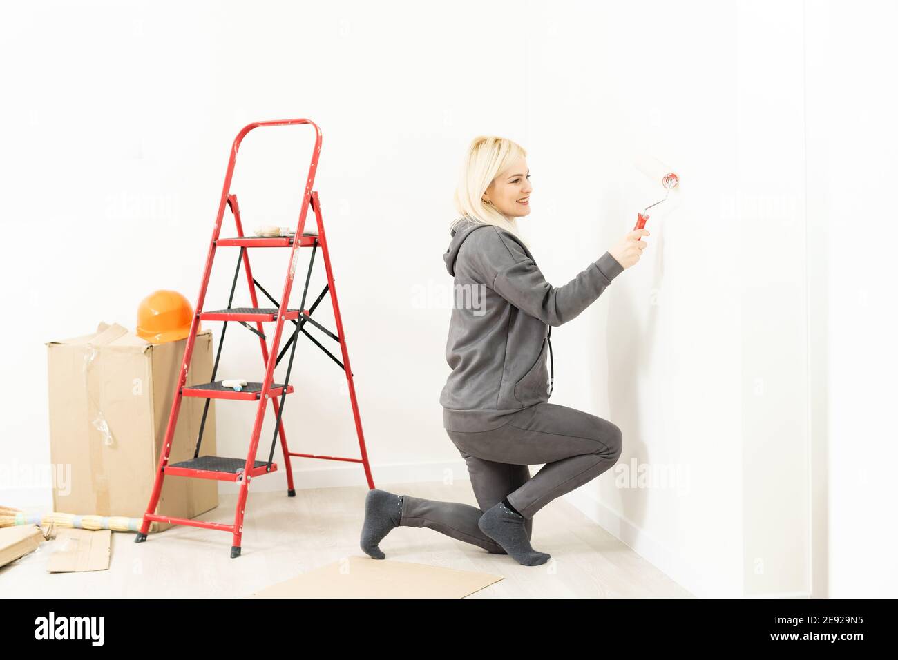 Happy beautiful young woman doing wall painting Stock Photo - Alamy