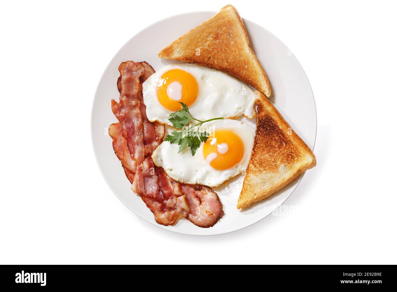 plate of fried eggs, bacon and toast isolated on white background, top ...