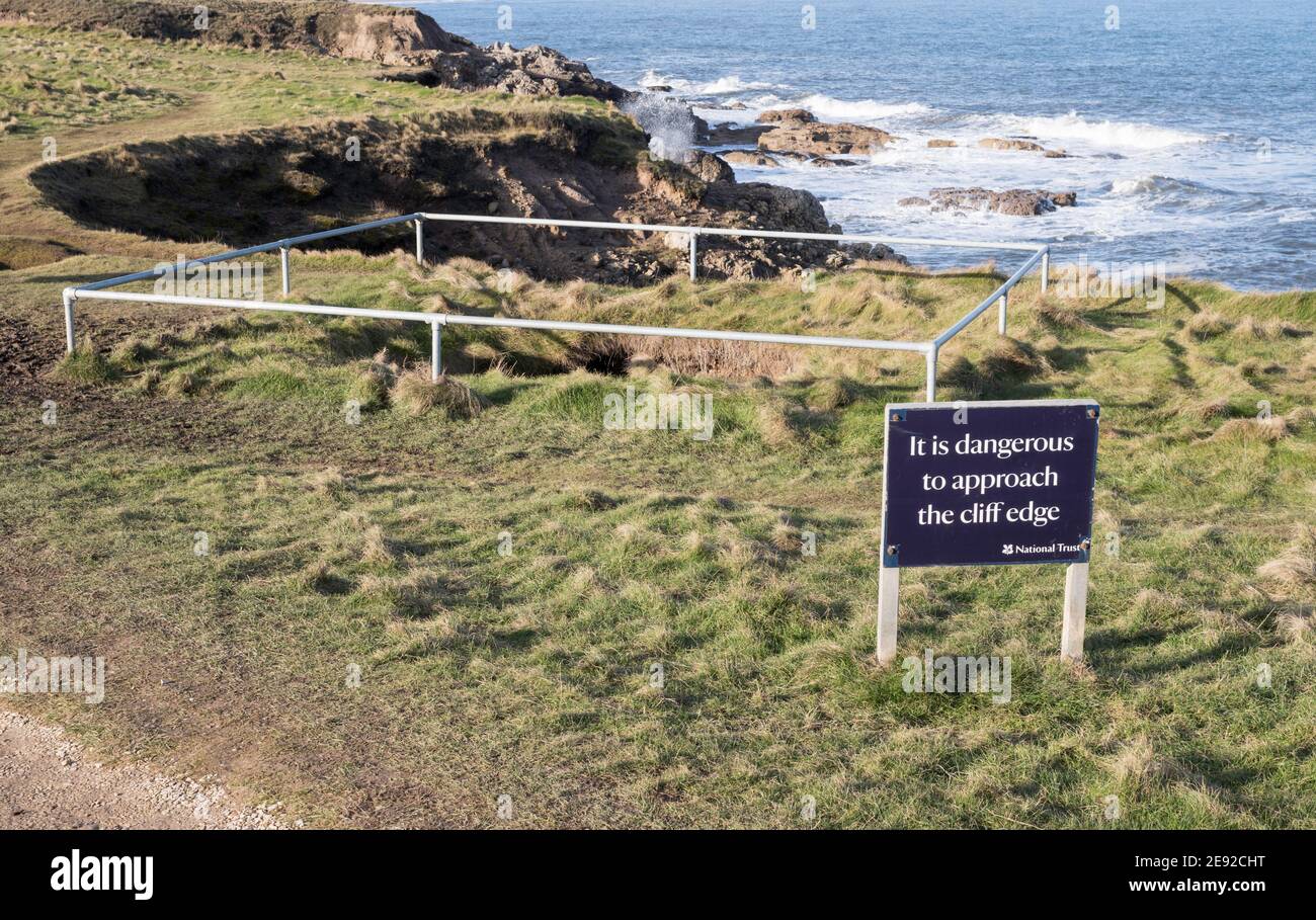 A sink hole and dangerous cliff edge notice between South Shields and Marsden, north east England, UK Stock Photo