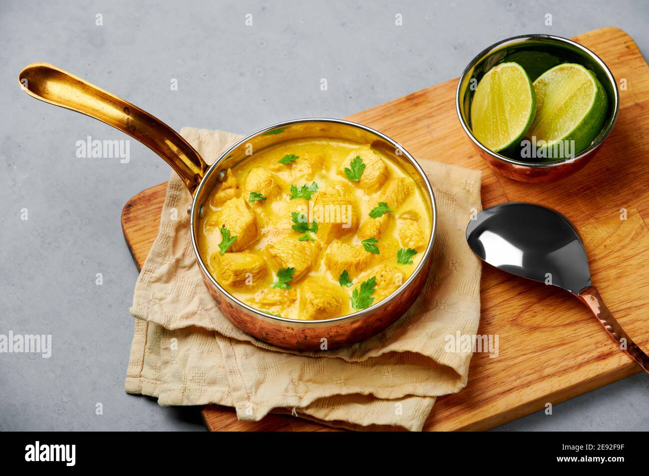 Chicken Korma in copper pan on gray concrete table top. Indian cuisine meat  curry dish with coconut milk masala. Asian food Stock Photo - Alamy