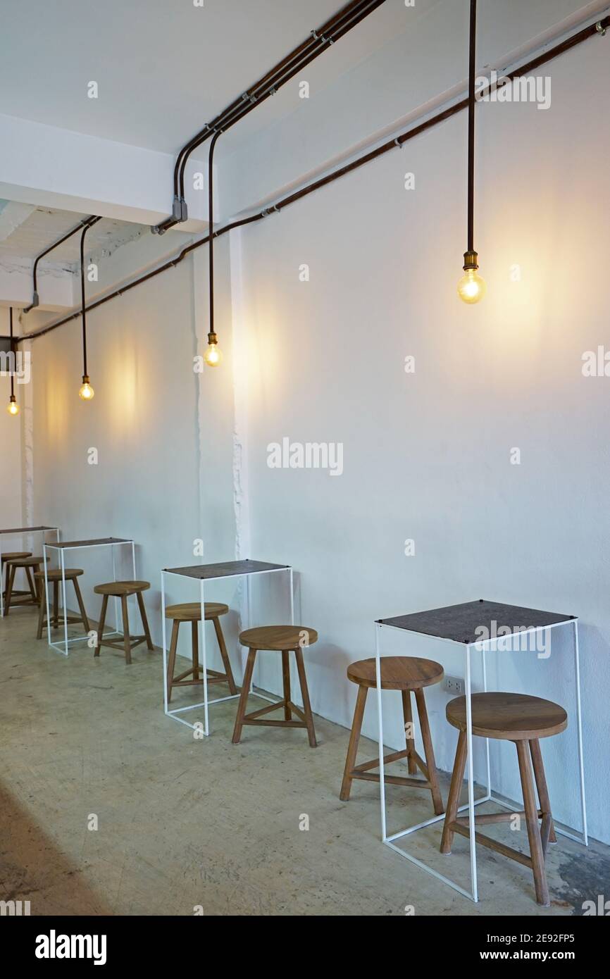 Lazy protection cement Interior design and decoration of coffee cafe and dining restaurant  decorated with wooden chair, hanging lamp and minimal furniture in white  wall room Stock Photo - Alamy