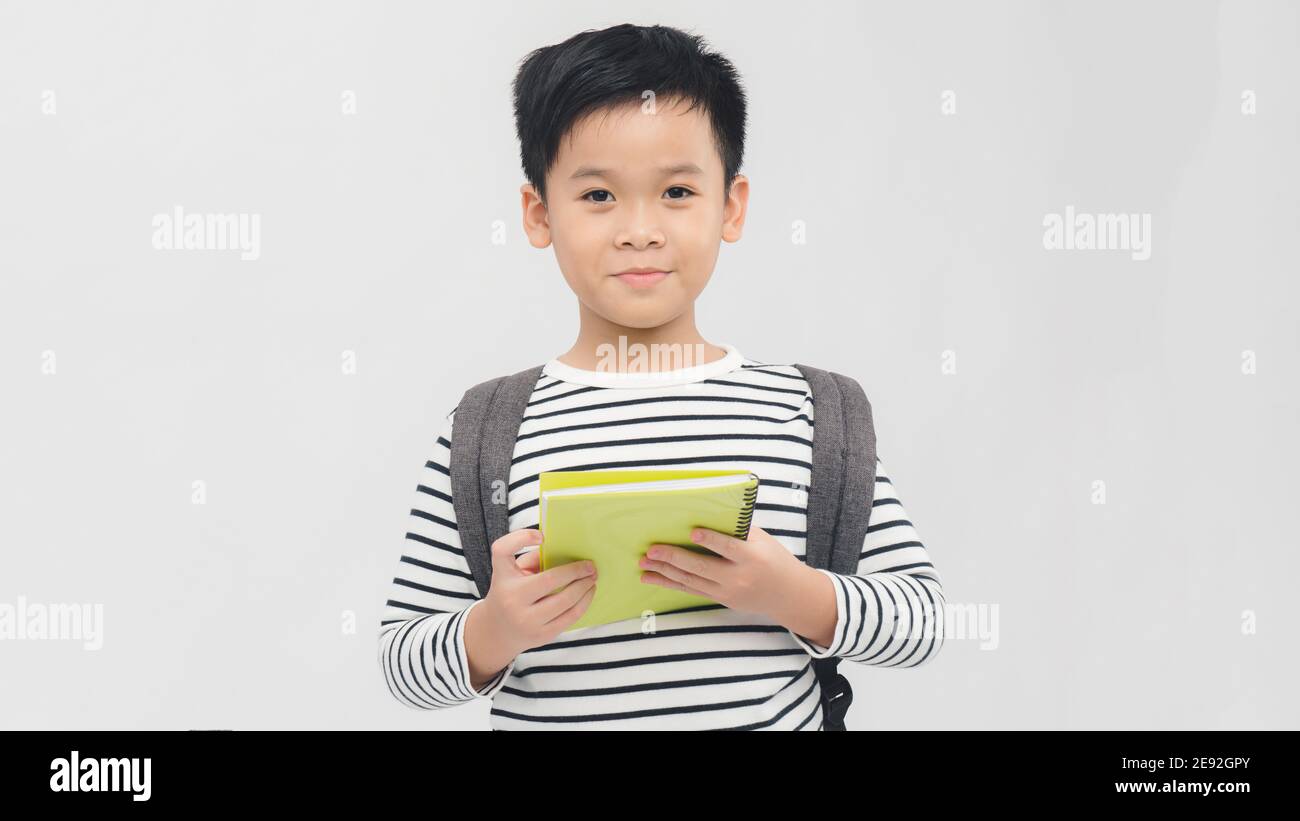 Portrait of little schoolboy with book on white background Stock Photo ...