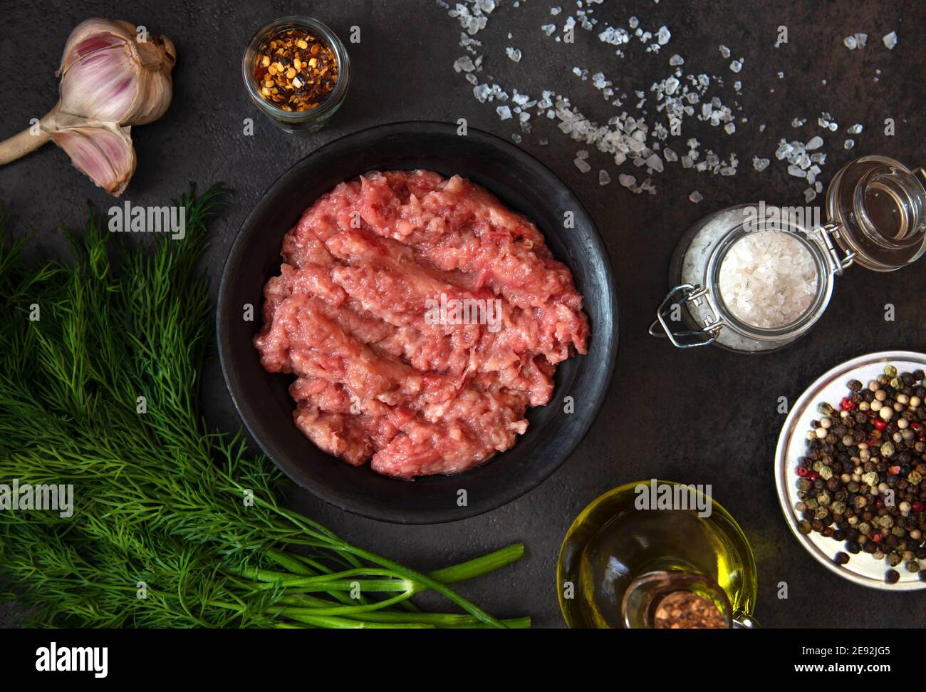 Homemade minced meat in a black bowl with ingredients. Fresh Raw mince. Top view. Stock Photo