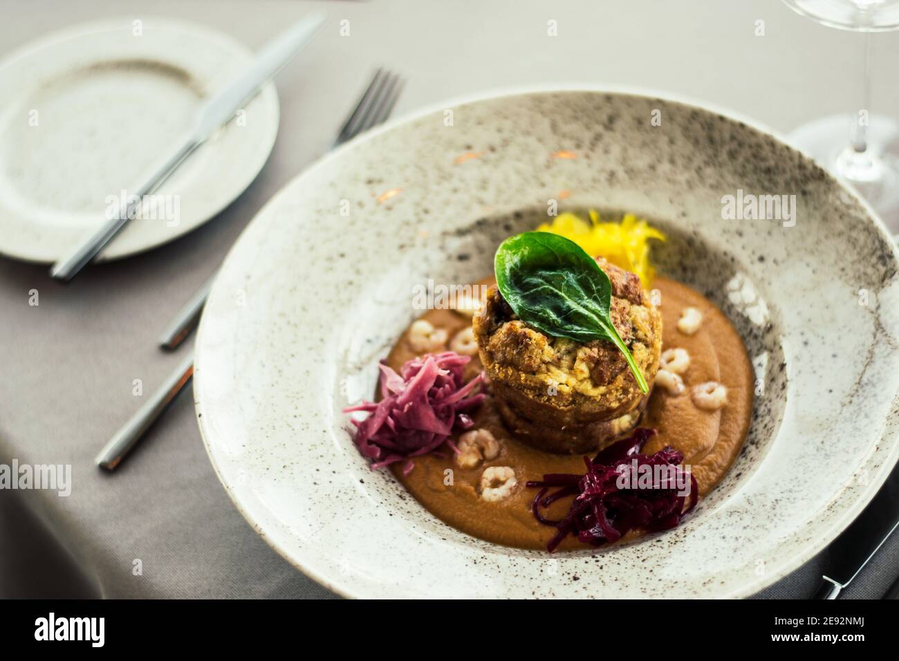 Pike cutlet with pumpkin sauce and fermented cabbage in different colors at a restaurant Stock Photo