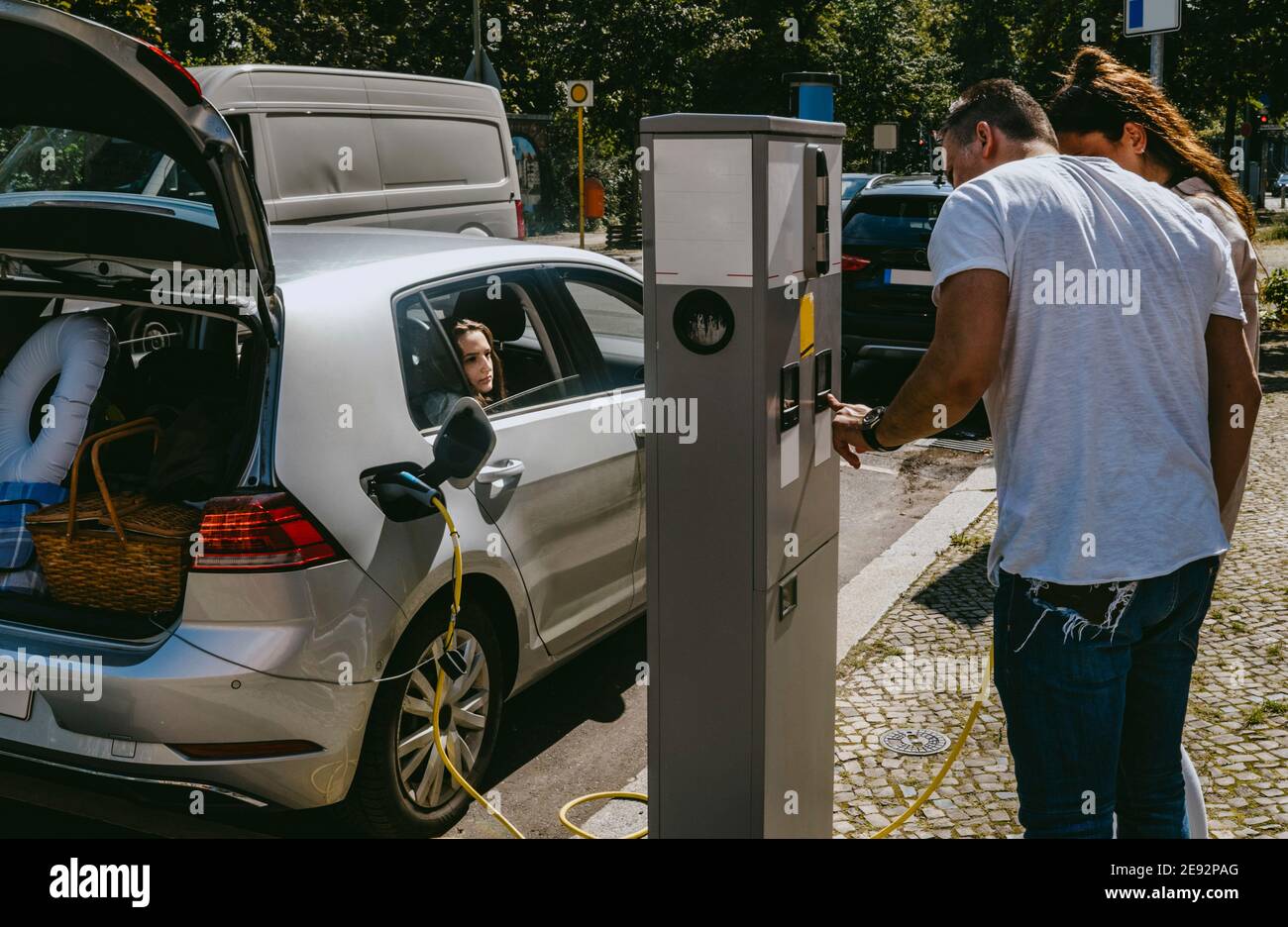 Mother and father checking charging of electric car at gas station Stock Photo