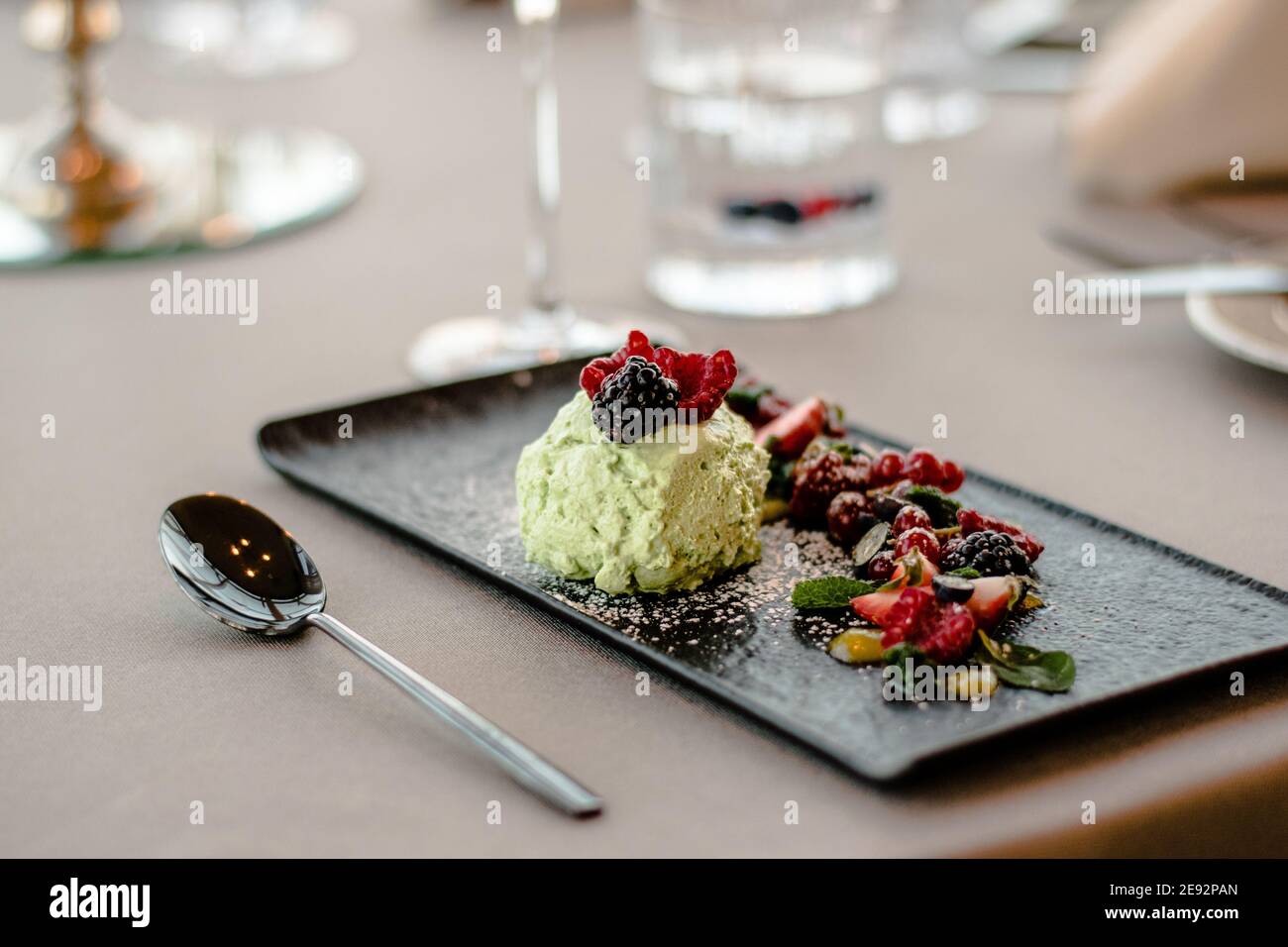 Ice cream on a black plate with fruits and sauce at a restaurant Stock Photo