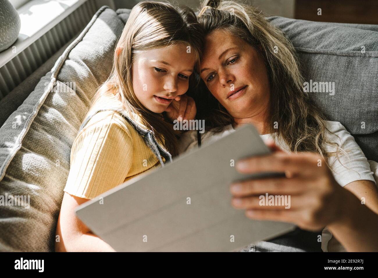 Mother and daughter using digital tablet at home Stock Photo