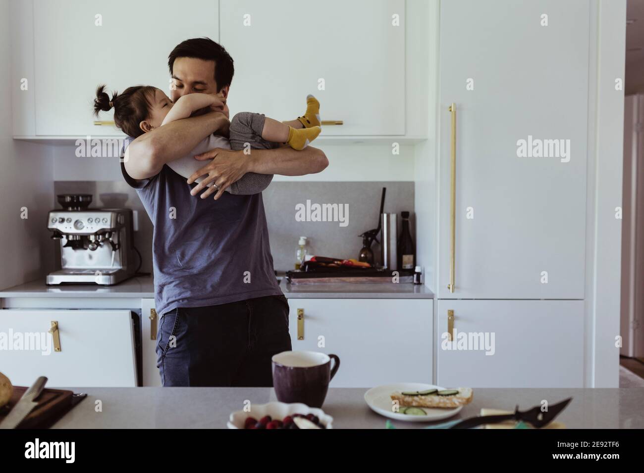 Father playing with son in kitchen at home Stock Photo