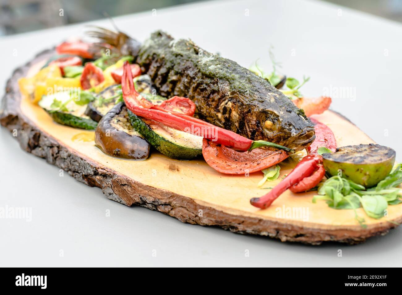 Fried fish on a wood plate at a restaurant Stock Photo