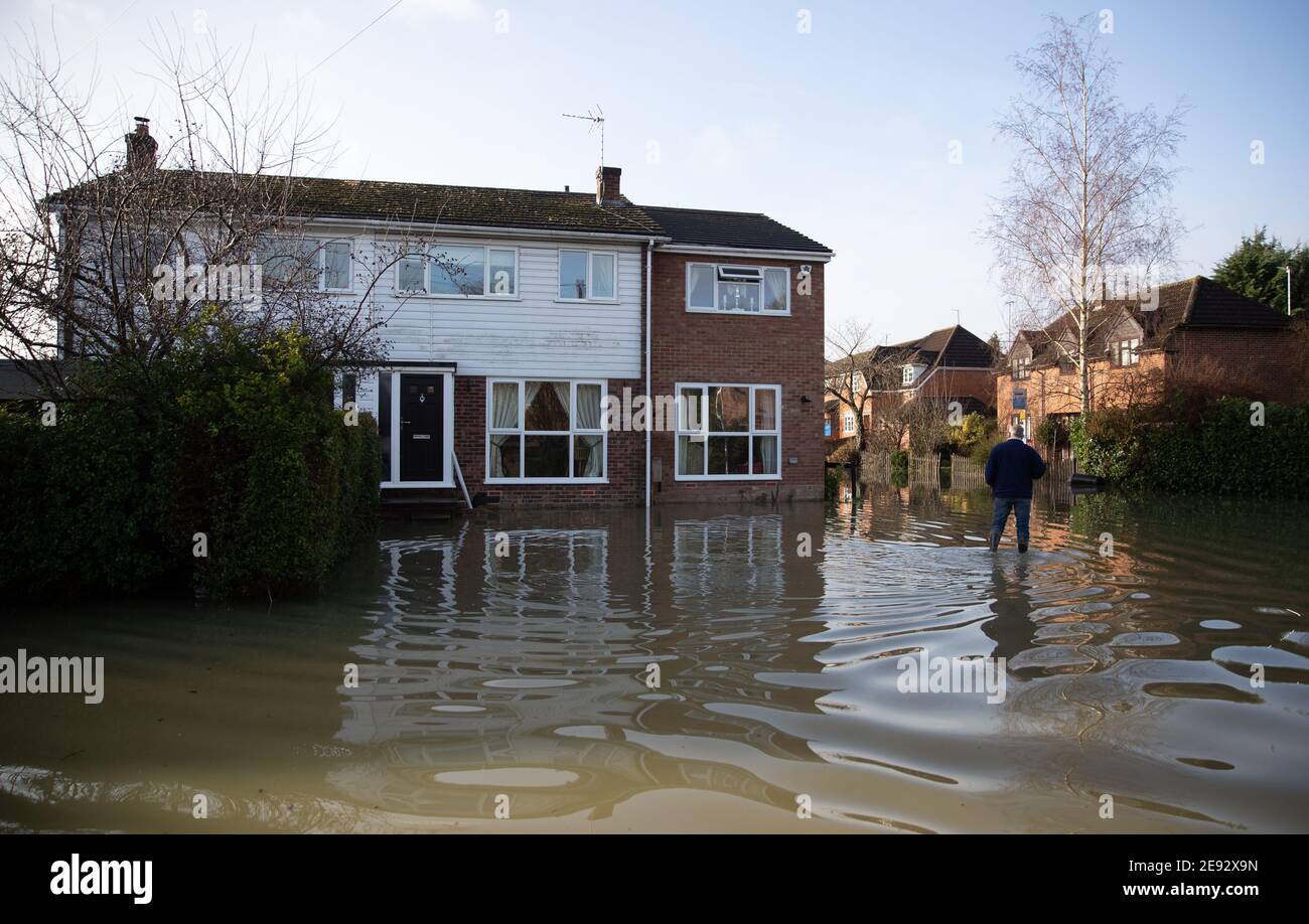 A person walks through floodwater in Purley on Thames in Berkshire. Picture date: Tuesday February 2, 2021. Stock Photo