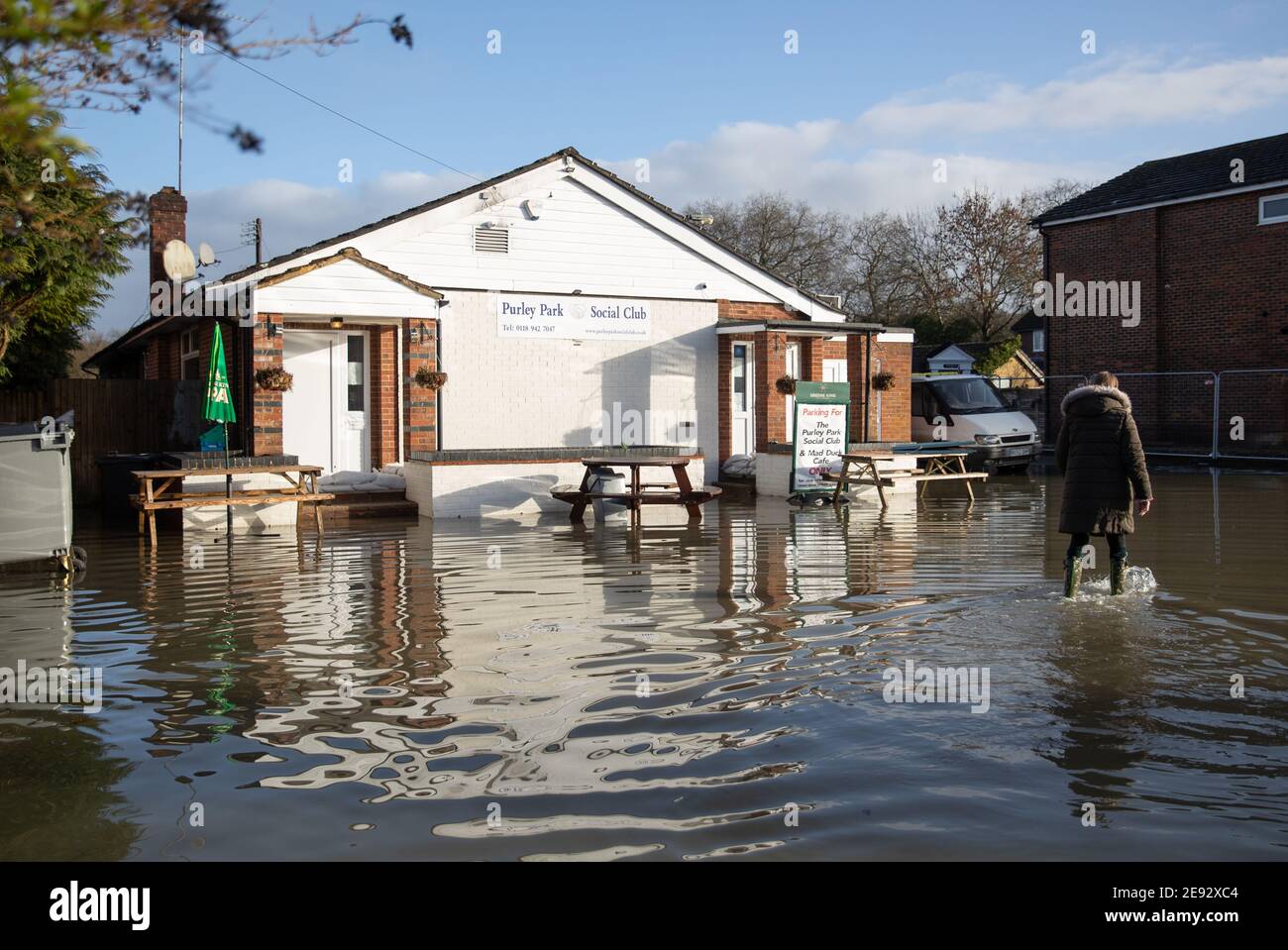 A person walks through floodwater next to the Purley Park Social Club in Purley on Thames in Berkshire. Picture date: Tuesday February 2, 2021. Stock Photo