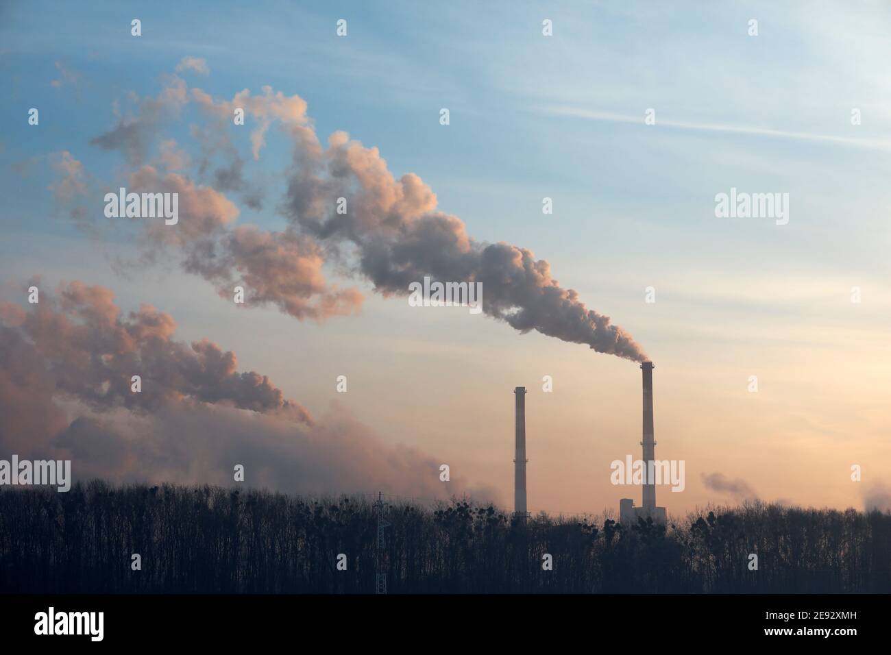 Steam from the factory at sunrise in winter Stock Photo