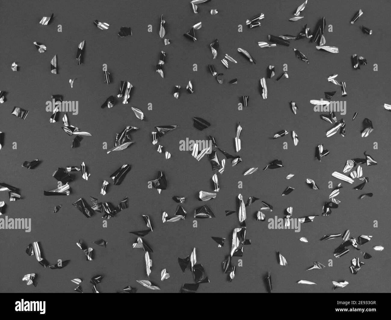 Confetti foil pieces on black background. Abstract festive backdrop. Stock Photo