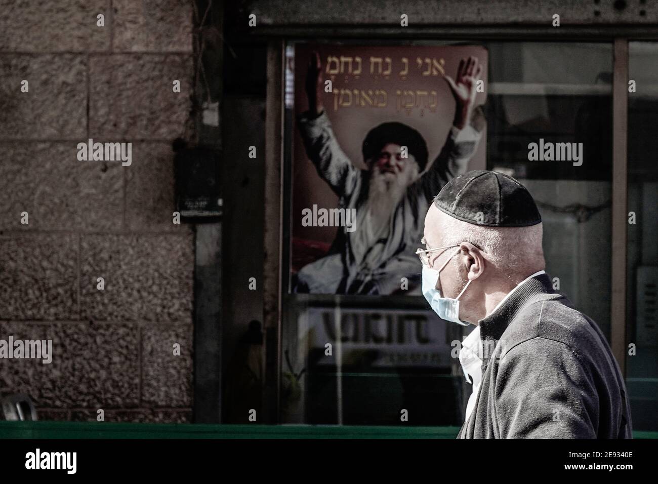 Jerusalem, Israel. 2nd Feb, 2021. A Jewish religious man walks past a banner depicting Rabbi Nachman of Breslov, believed by some to be the messiah, at Jerusalem's Shuk Mahane Yehuda Market. Credit: Nir Alon/Alamy Live News Stock Photo