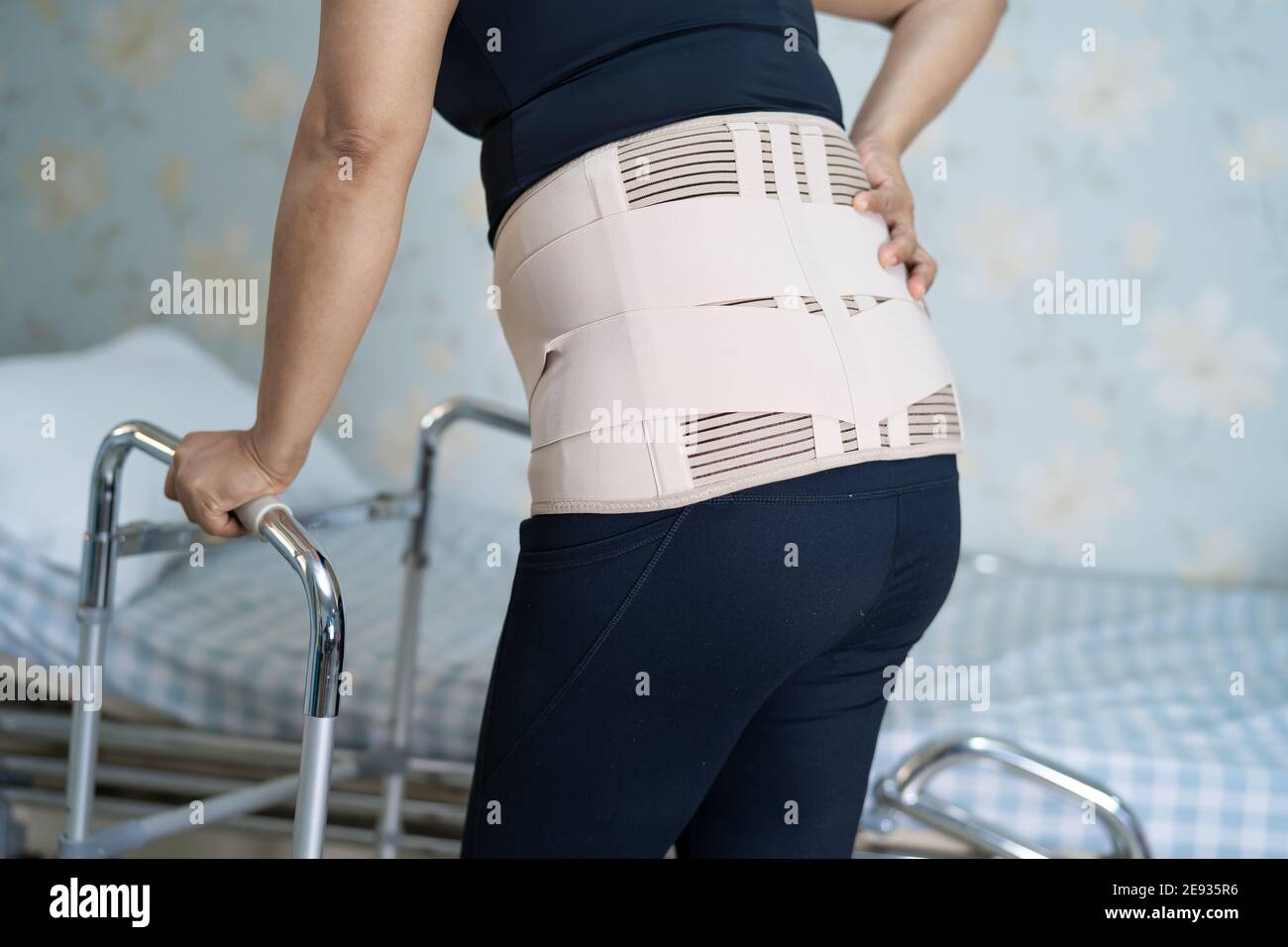 Asian lady patient wearing back pain support belt for orthopedic lumbar