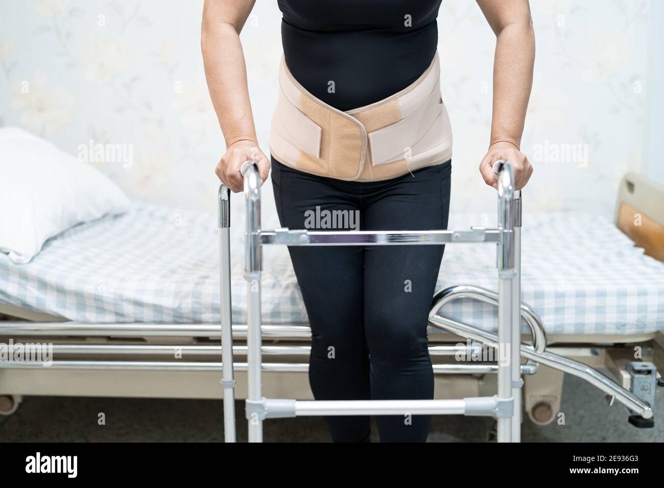 Asian lady patient wearing back pain support belt for orthopedic lumbar