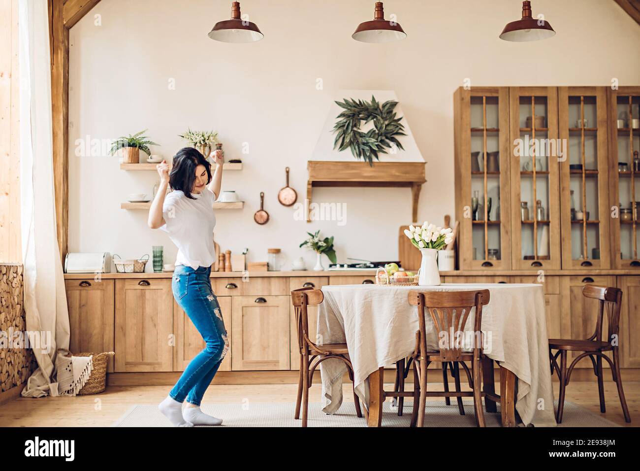 A young girl performs a joyful victory dance in the middle of the kitchen at home Stock Photo
