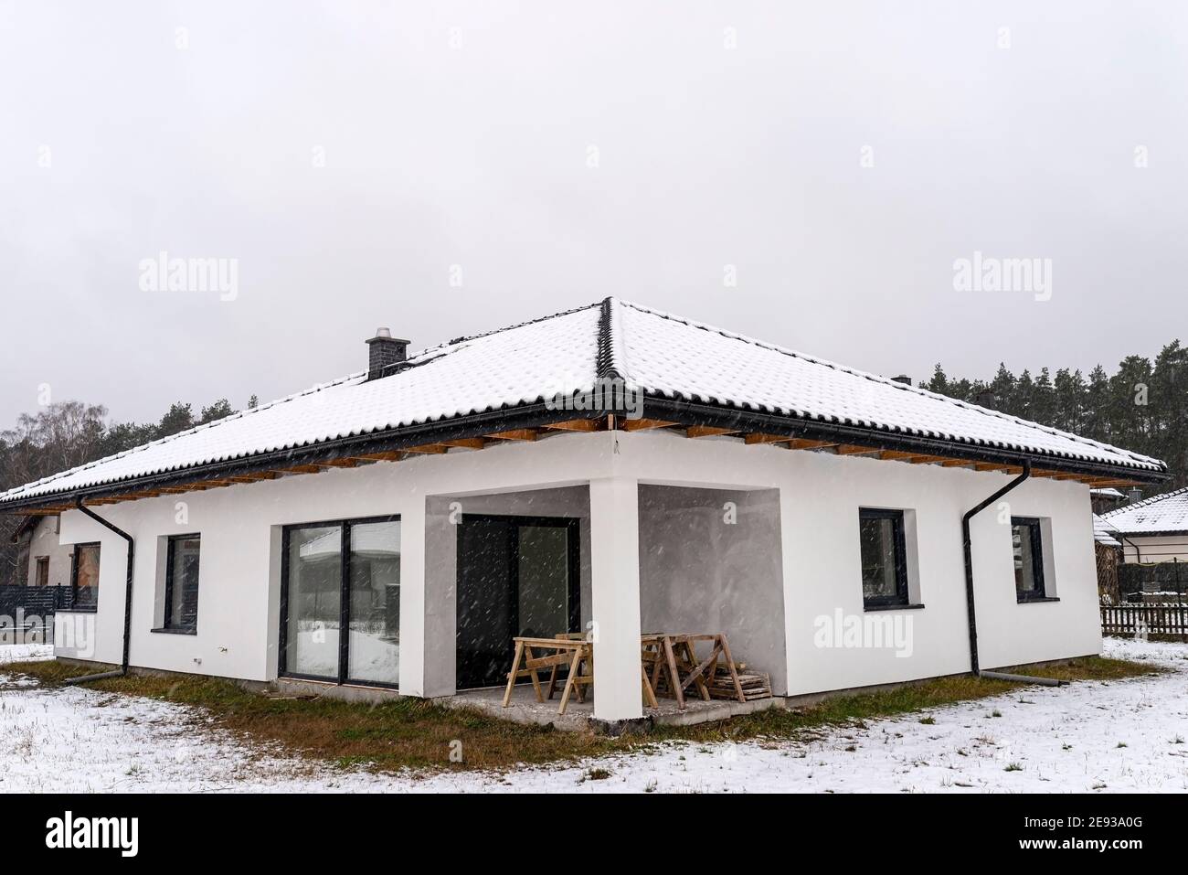 Single-family house roof covered with snow against a cloudy sky ...