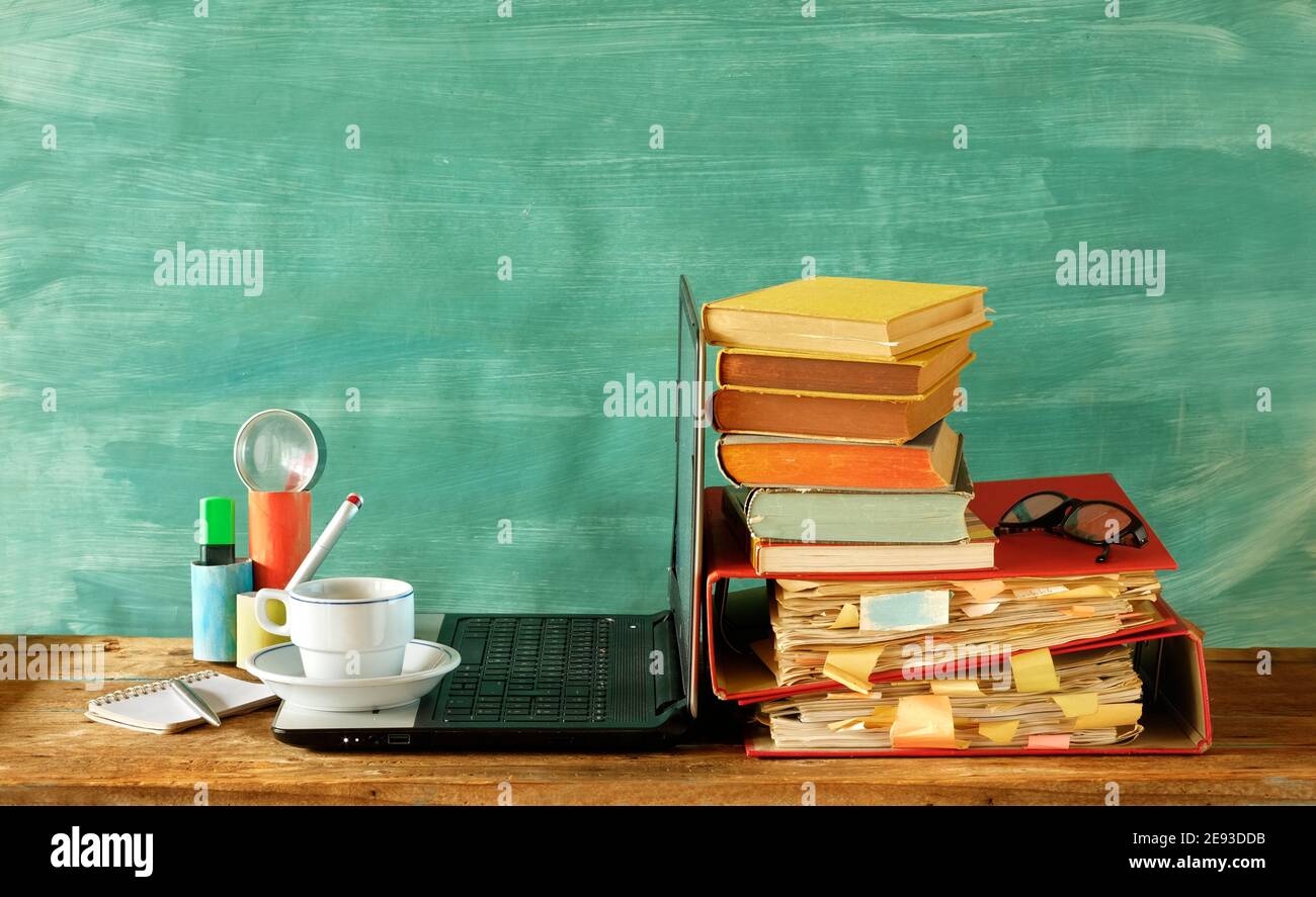 home offiice,education,business,homeschooling concept with laptop computer row of books, file folders, office supplies and cup of coffee Stock Photo