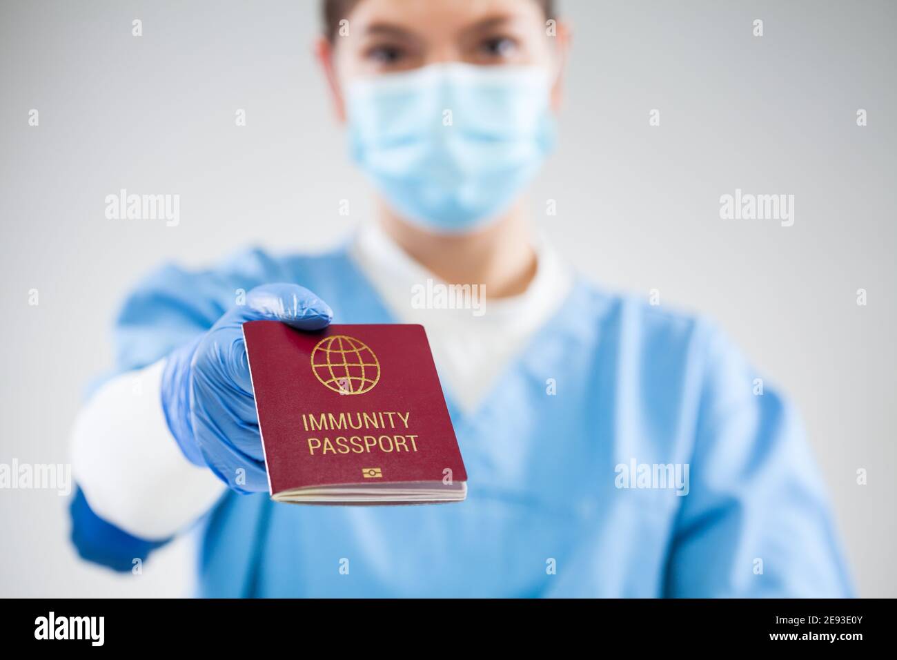 UK NHS doctor holding red global immunity passport,SARS re-infection risk-free certificate concept,recovered COVID-19 patient receive proof of convale Stock Photo