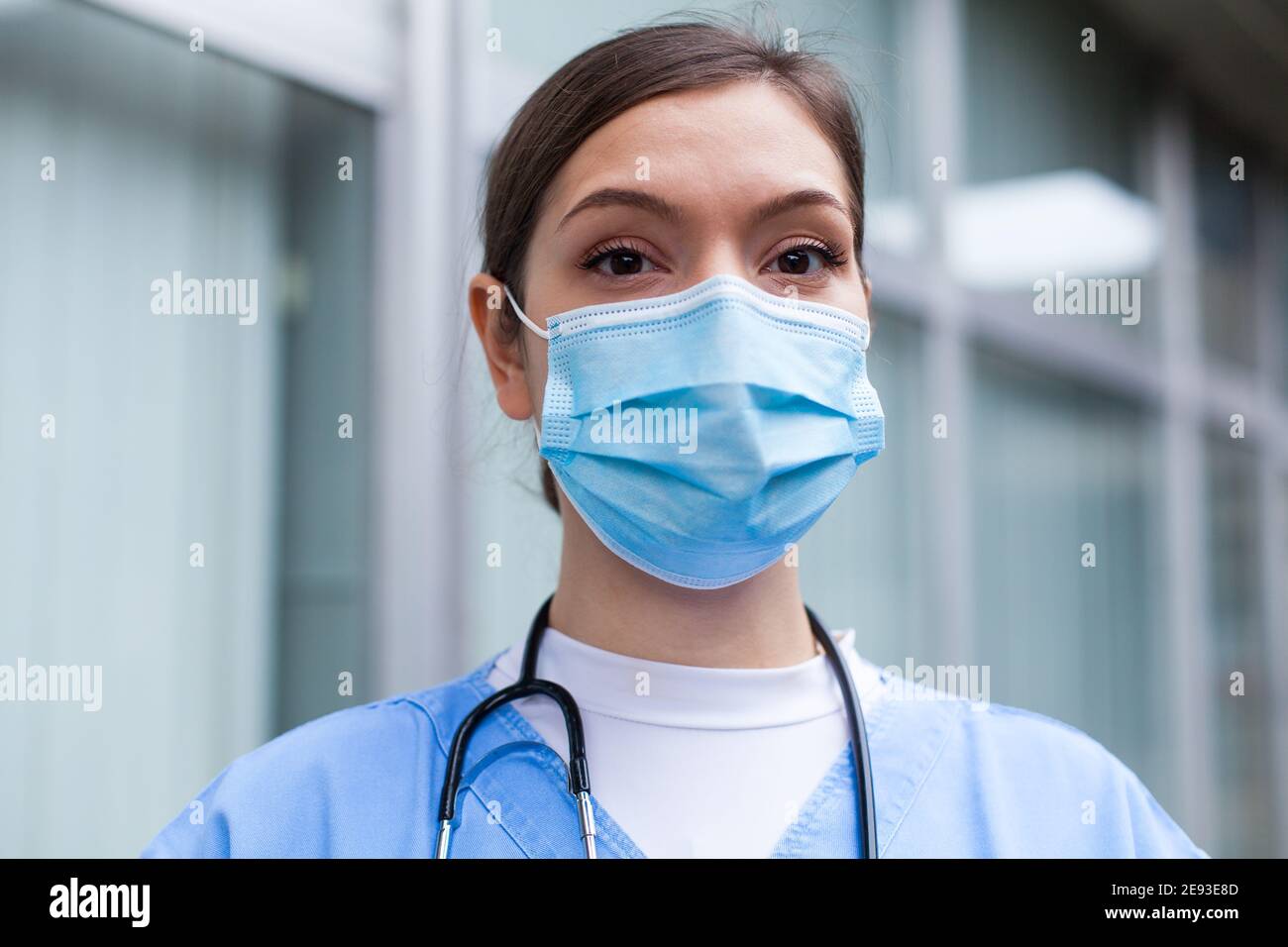 Closeup portrait of very tired exhausted UK NHS ICU doctor in front of hospital,Coronavirus COVID-19 pandemic outbreak crisis,sleep deprived EMS medic Stock Photo
