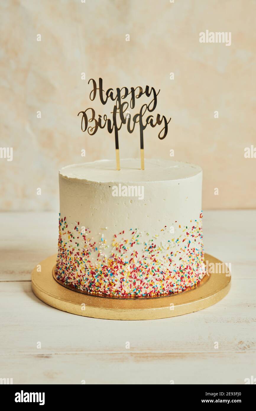 Cake with a ''happy birthday'' cake topper and sprinkles on a ...