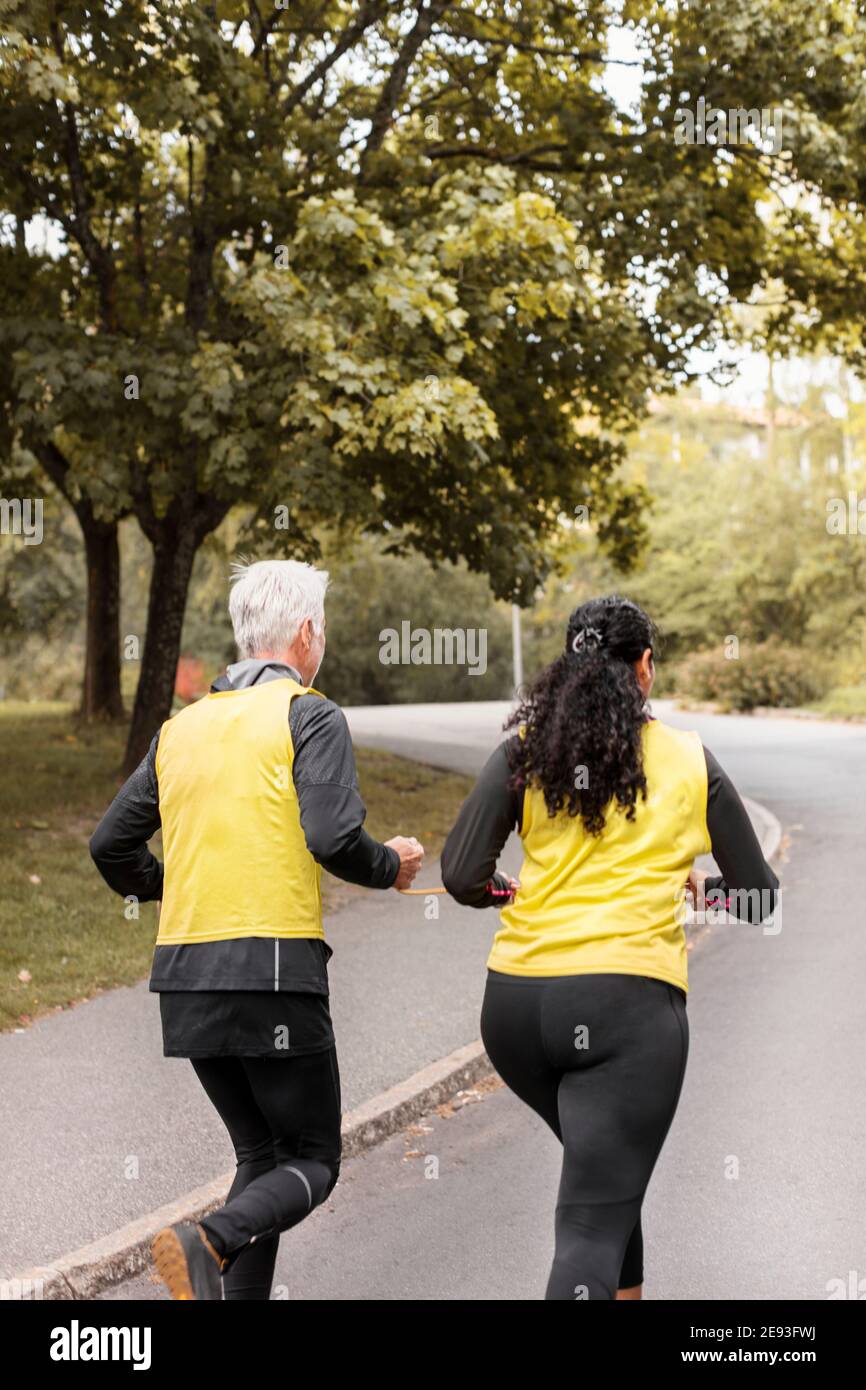 Visually impaired woman jogging with guide runner Stock Photo Alamy