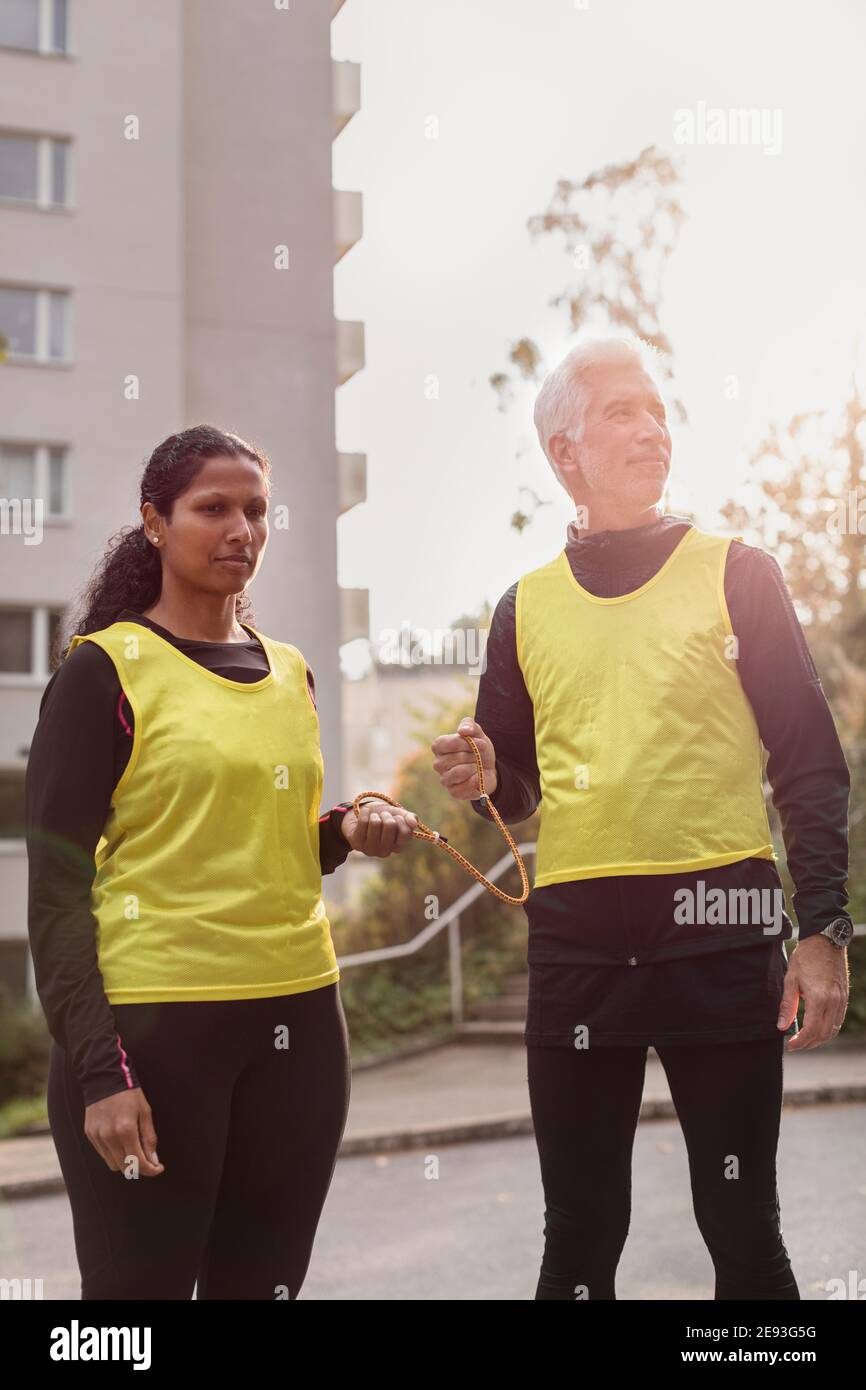 Visually impaired woman preparing for jogging with guide runner Stock Photo