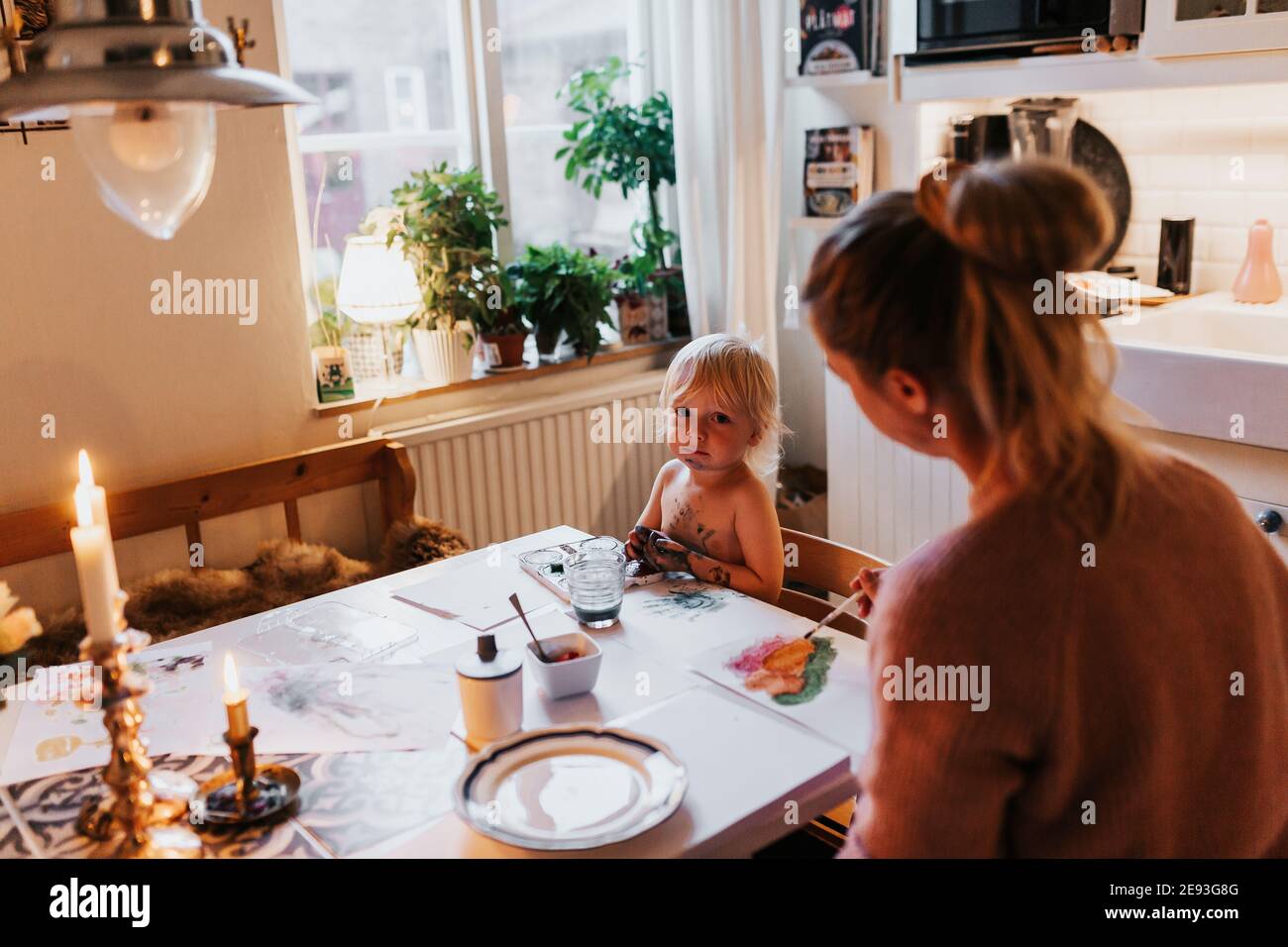 Mother and toddler painting at table Stock Photo