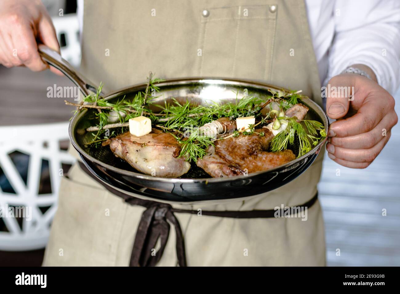 Chef preparing quail in a pan at a restaurant Stock Photo