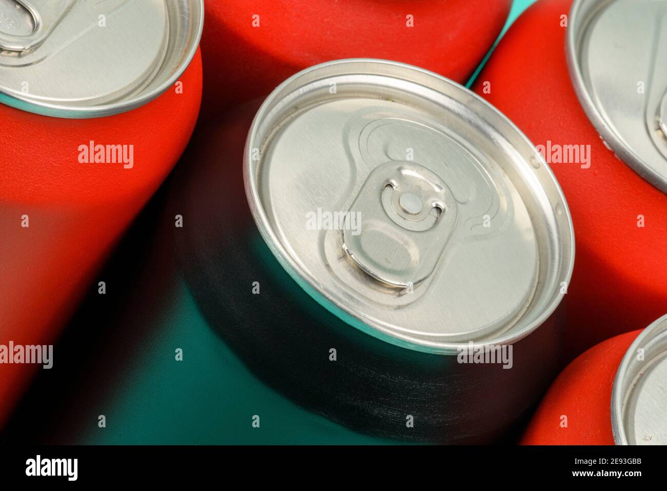 red soda cans lined up seen from above with a mixed black can Stock
