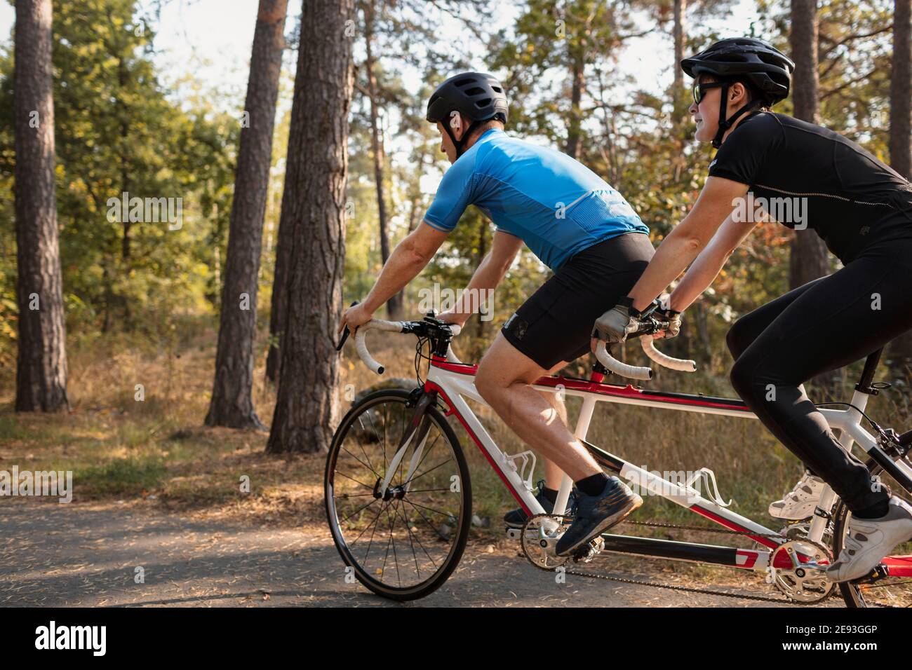 Visually impaired female triathlete training on tandem bicycle with her guide and coach Stock