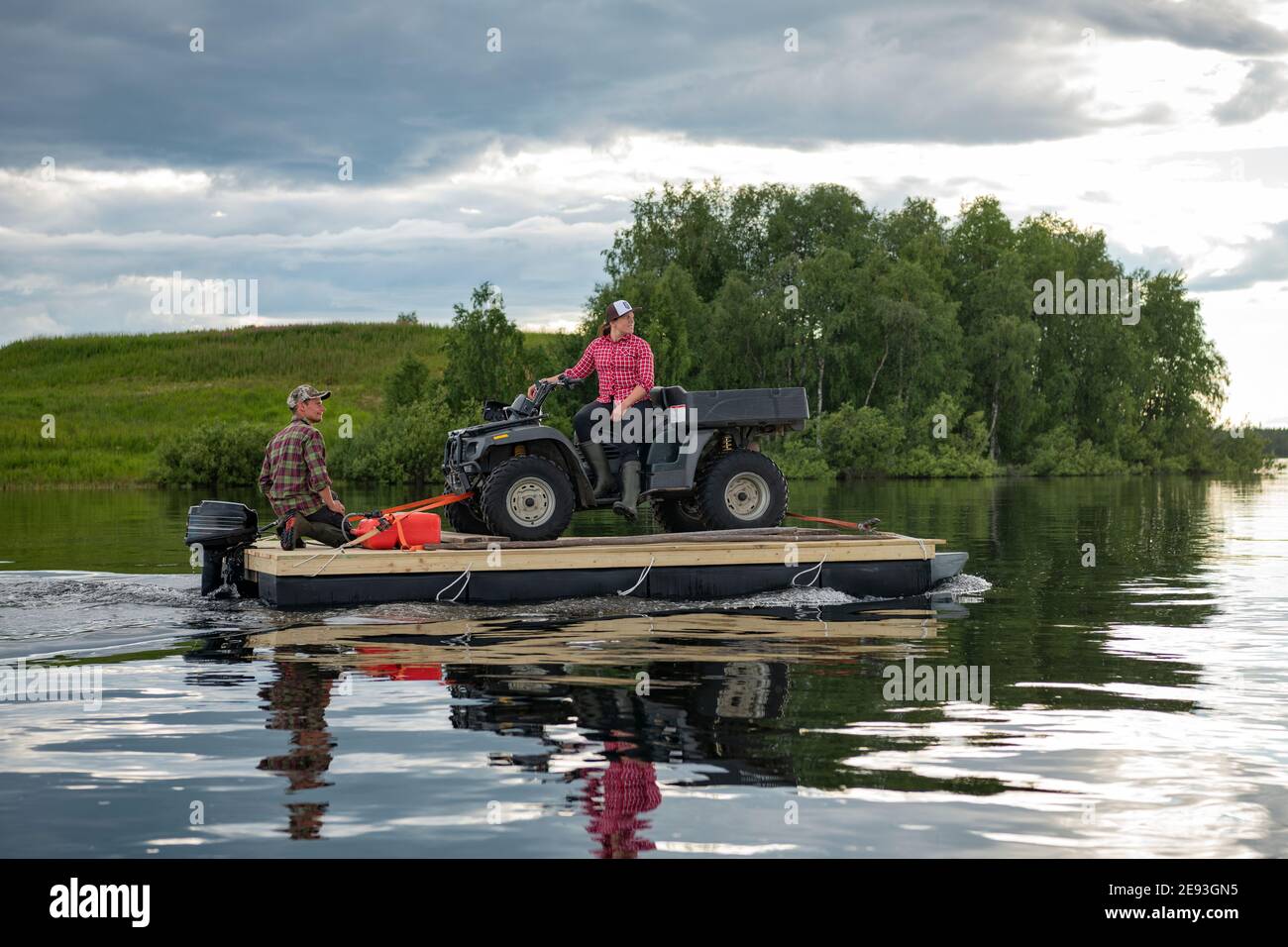 Couple transporting quadbike on motor raft Stock Photo - Alamy