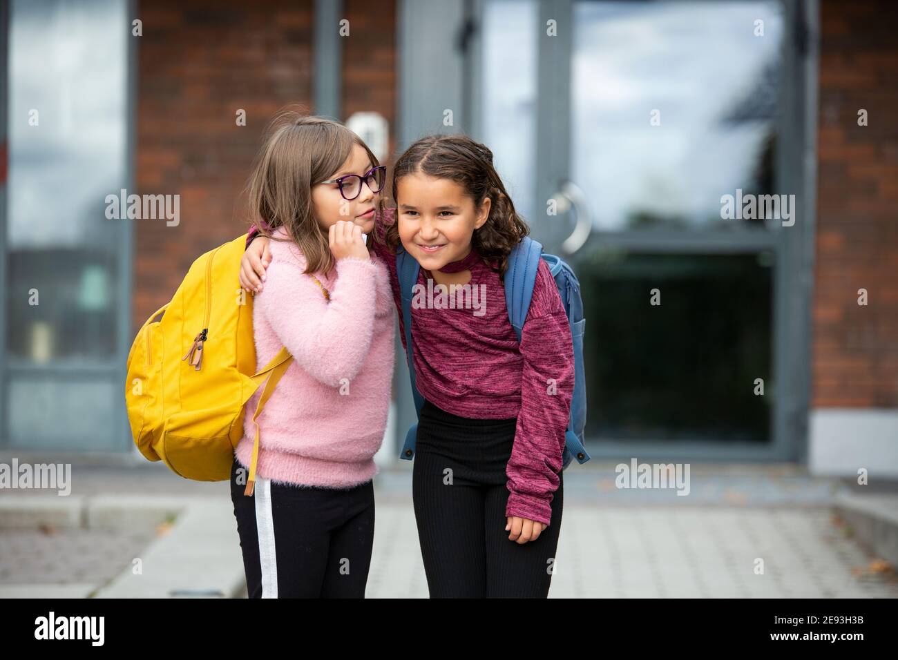 Girls standing in front of school Stock Photo - Alamy