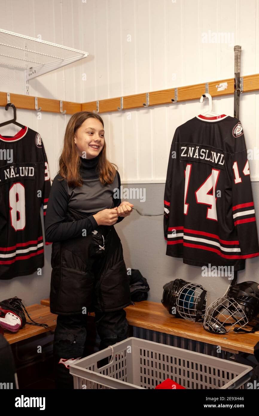 Girl hockey player dressing in locker room Stock Photo Alamy