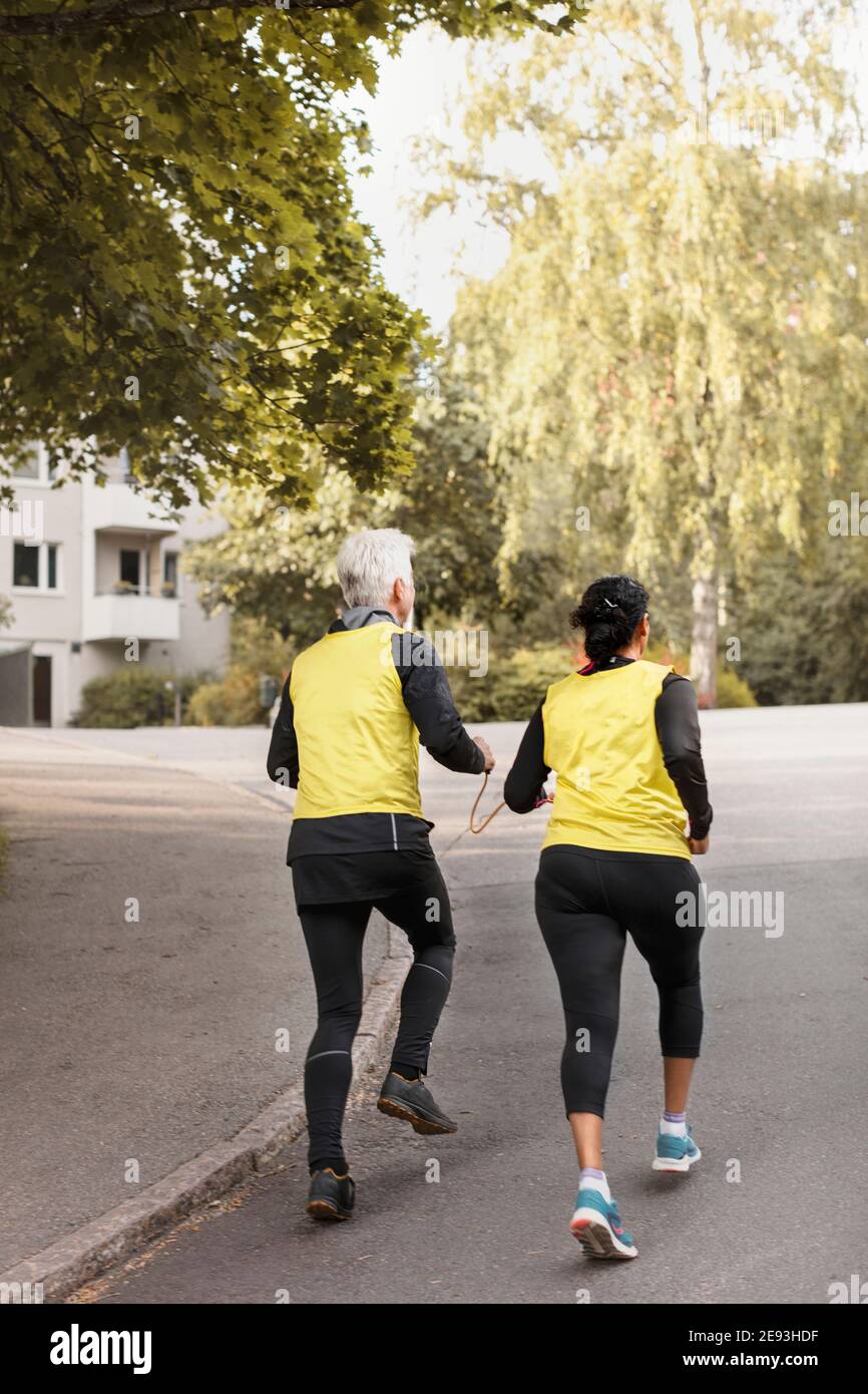 Visually impaired woman jogging with guide runner Stock Photo