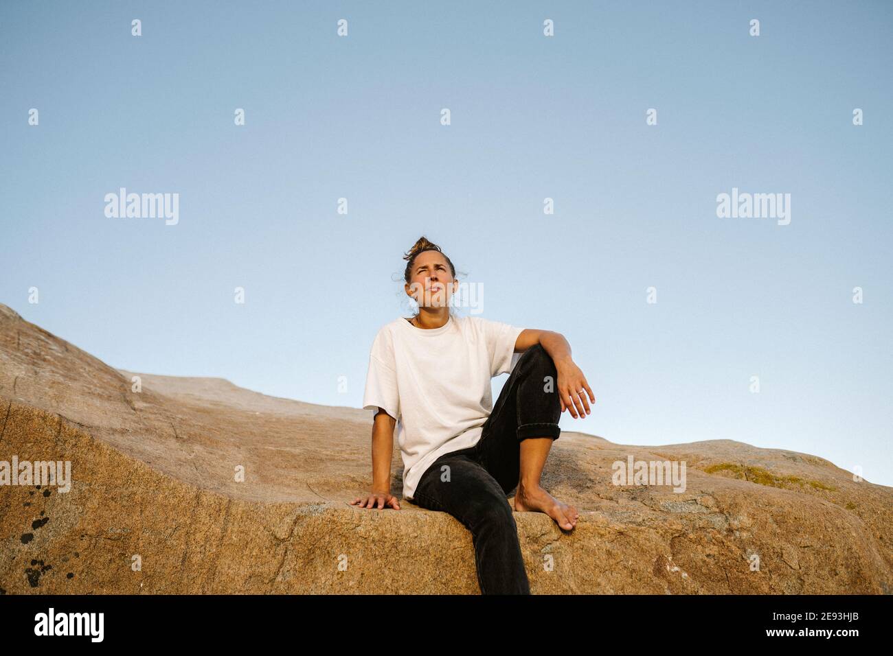 Woman sitting on rock Stock Photo