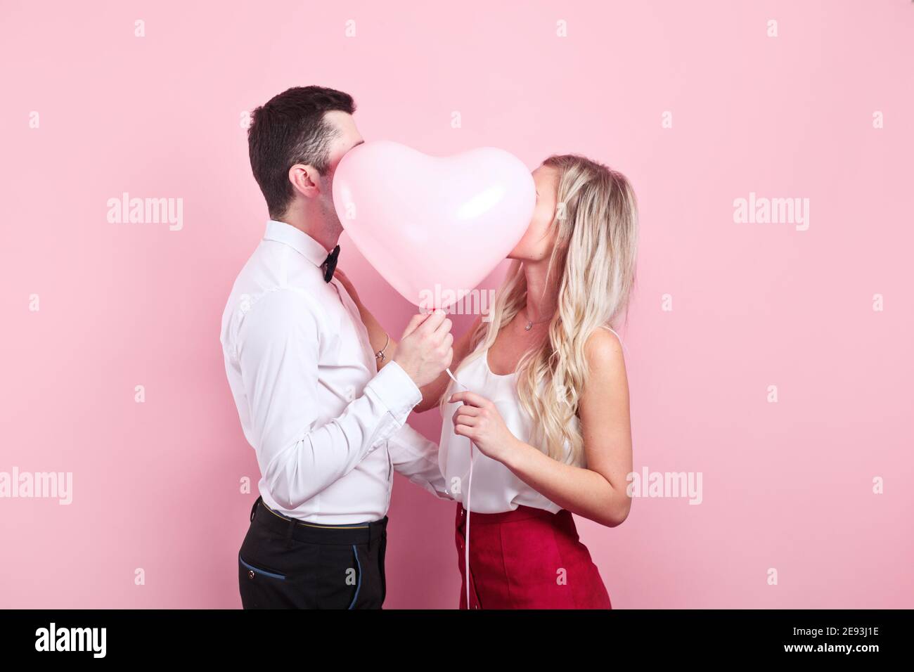 Valentines day. Beautiful romantic couple with heart balloon on pink ...