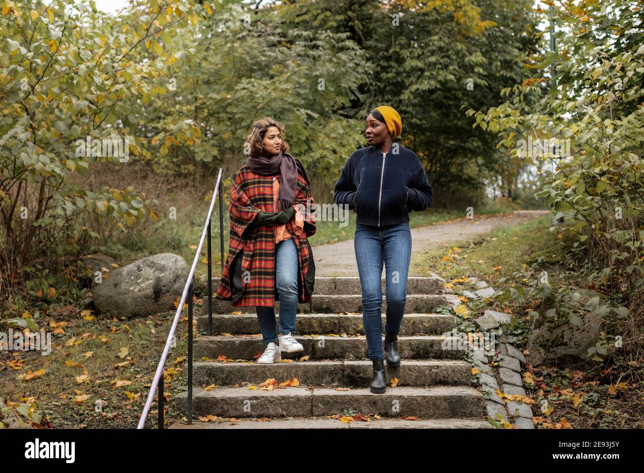 Two young women walking in park Stock Photo - Alamy