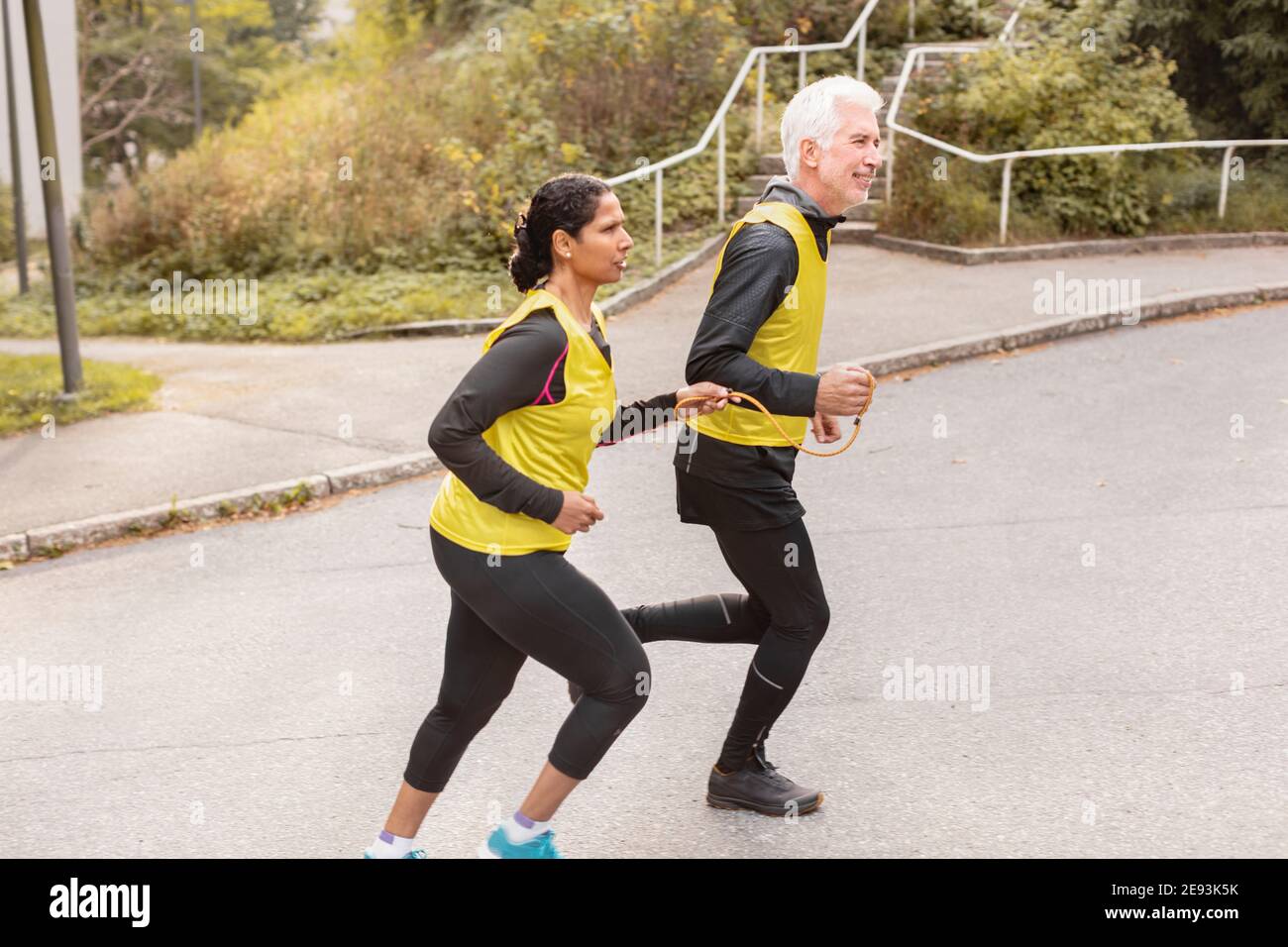 Visually impaired woman jogging with guide runner Stock Photo Alamy