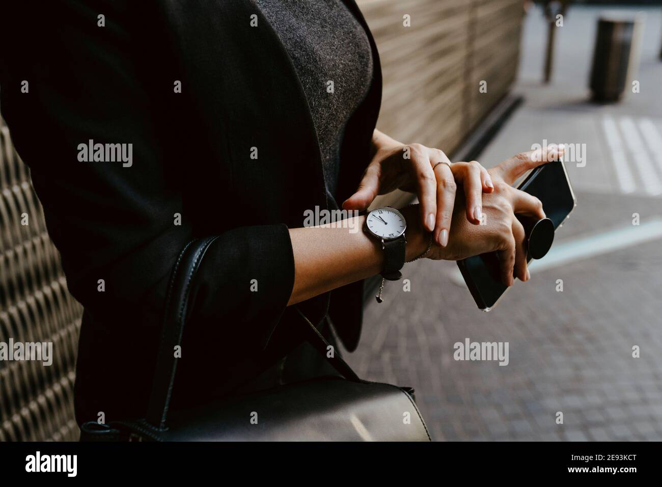 Midsection of businesswoman checking time on wristwatch Stock Photo